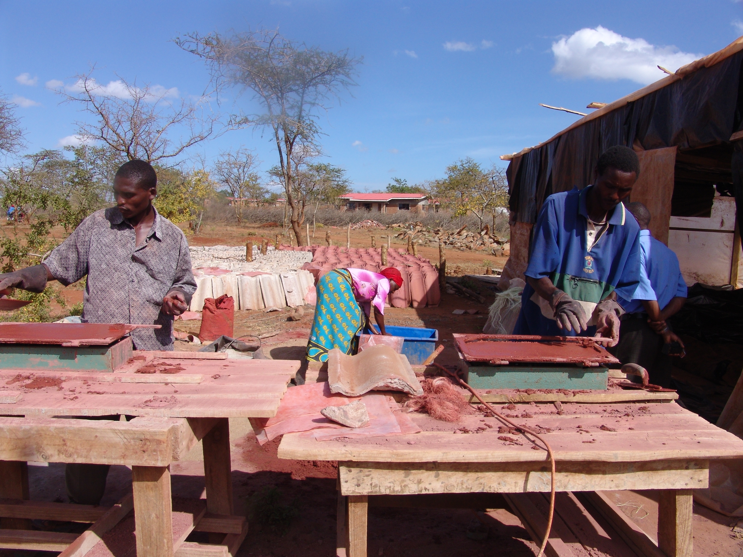 Construction workers learn to make clay roofing tiles at Nyumbani Village in Kenya