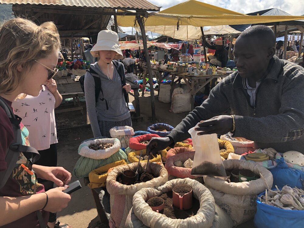 Cal Poly volunteers visit a spice vendor at the Same Sunday Market