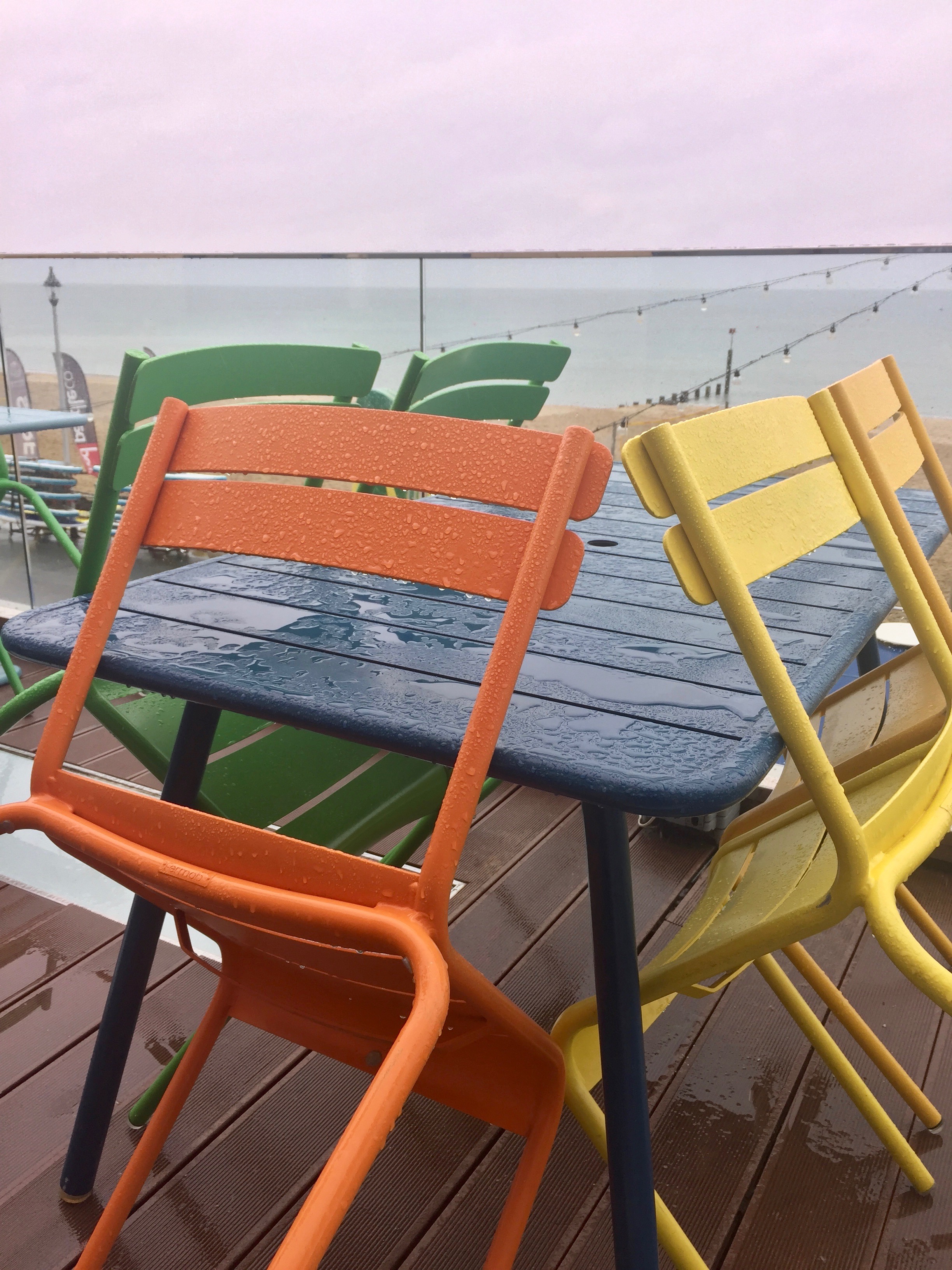 Beach cafe in the rain. Pretty chairs.