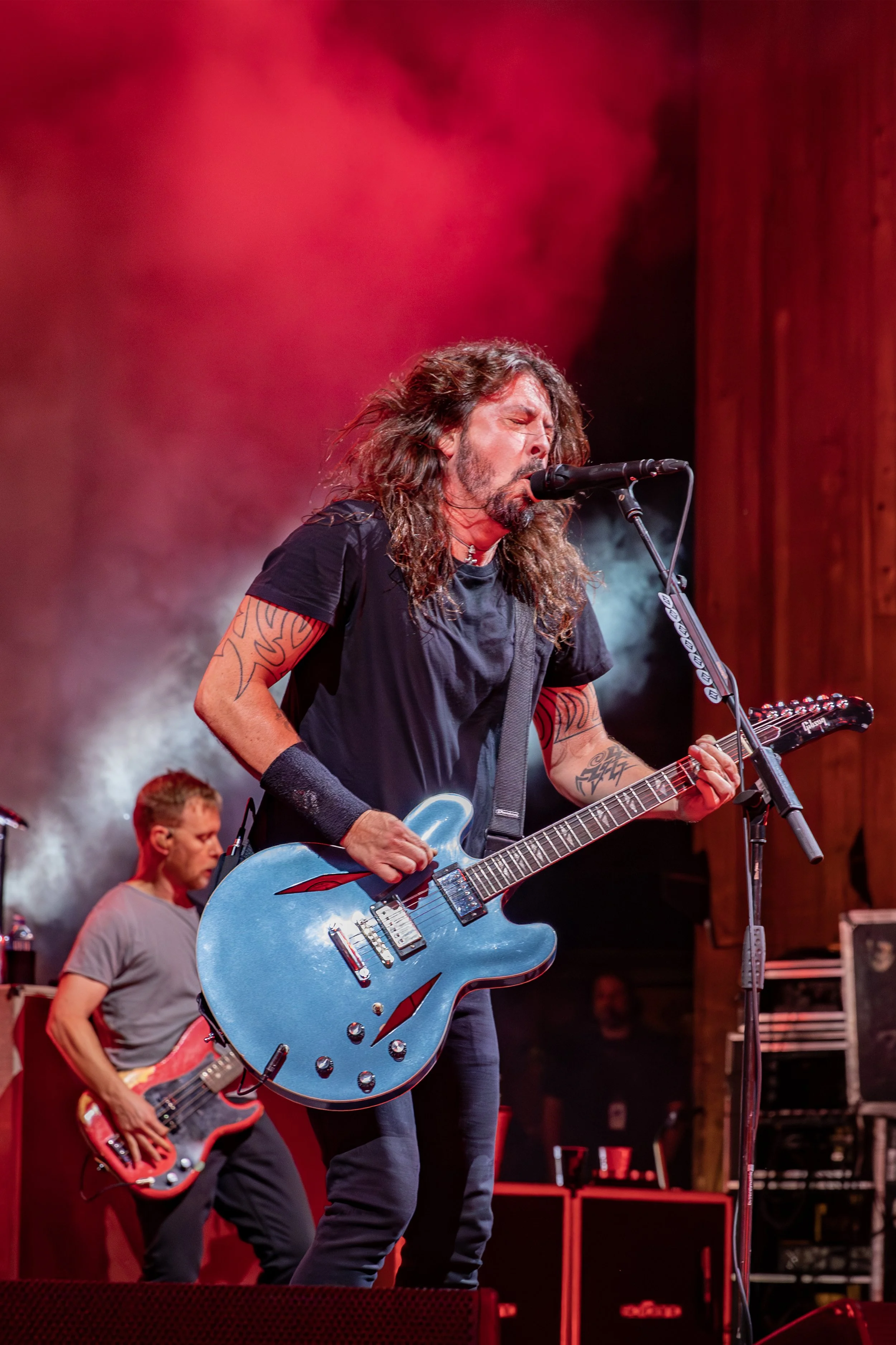 Dave Grohl live against red smoke and bassist Nate Mendel at Blossom Music Center in Cuyahoga Falls - Harry Acosta Photography