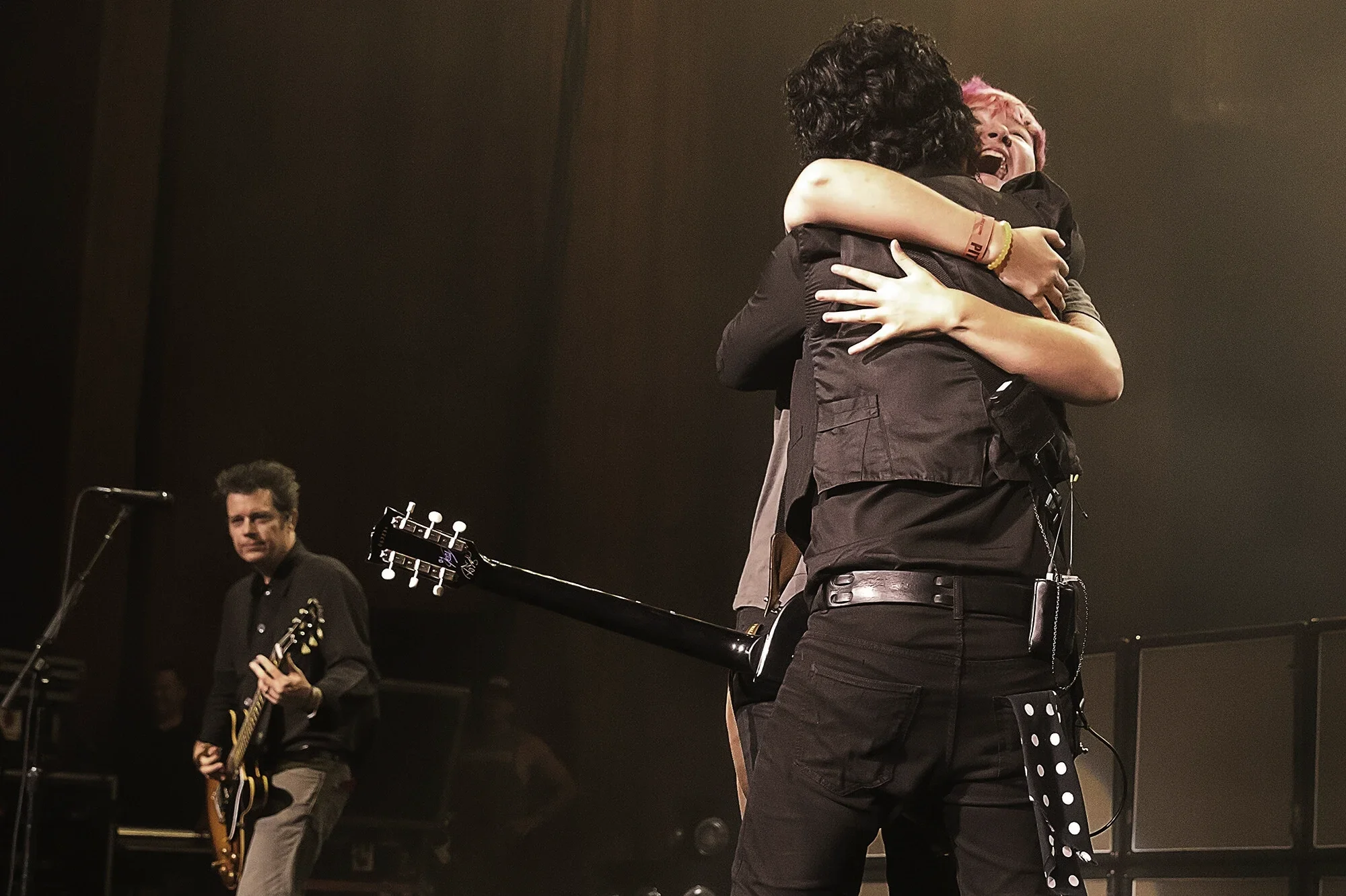 Billie Joe Armstrong embraces a fan on stage at Blossom Music Center by Harry Acosta Photography