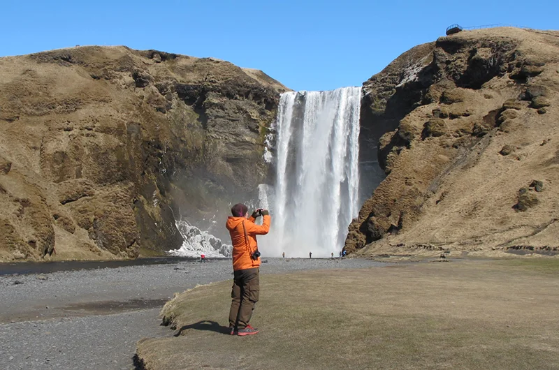 Espen tar bilder ved Skogafoss.