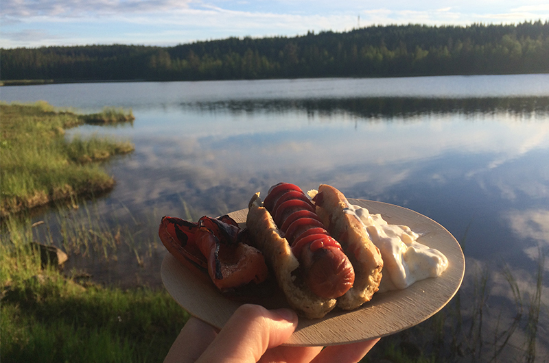 Pølse i solnedgang. Servert i pølsebrød/ pinnebrød laget på bål, potetsalat og paprika stekt i glør.