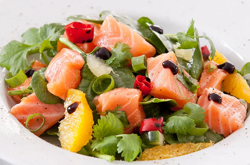 Rå laks og koriander passer perfekt sammen og i denne salaten kombineres de på en frisk, lett og lekker måte. Oppskrift finner du på side 65 i boka LavFODMAP - Magevennlig mat. Foto: Magevennlig mat v/ Espen Døhlen