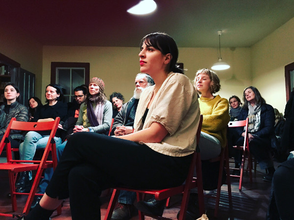 Artist/writer Annie Bielski listening to her co-readers at LEX*I*CON reading.