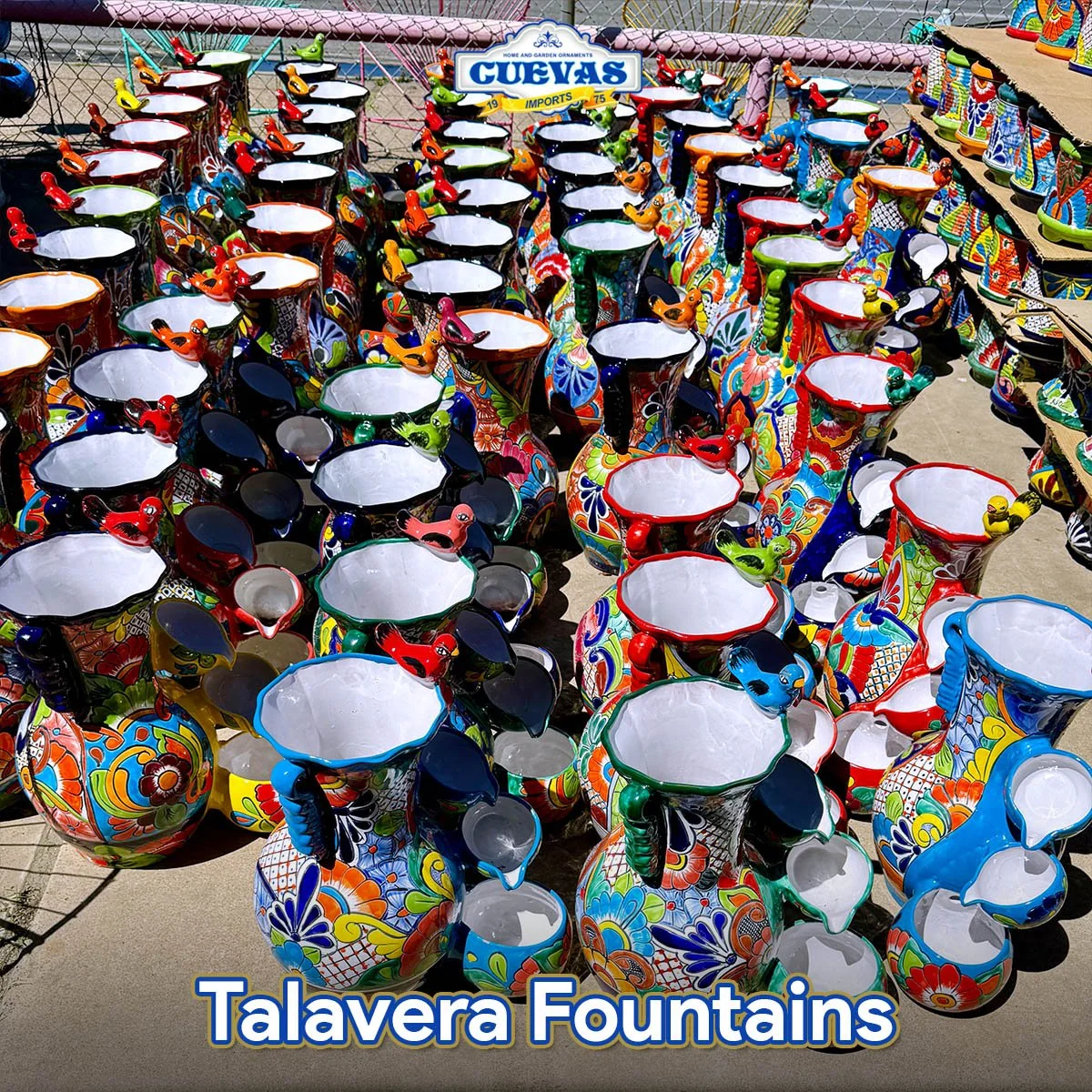 Colorful Talavera pottery fountains with intricate floral and geometric designs, displayed outdoors at a market.