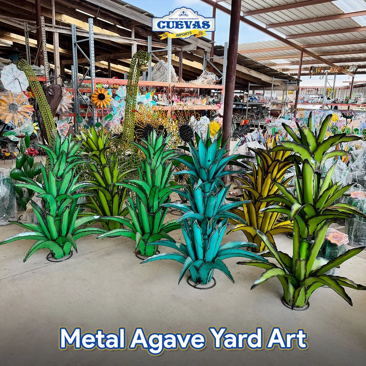 Colorful metal agave yard art sculptures resembling large agave plants, arranged in front of a store with garden ornaments and decorations.