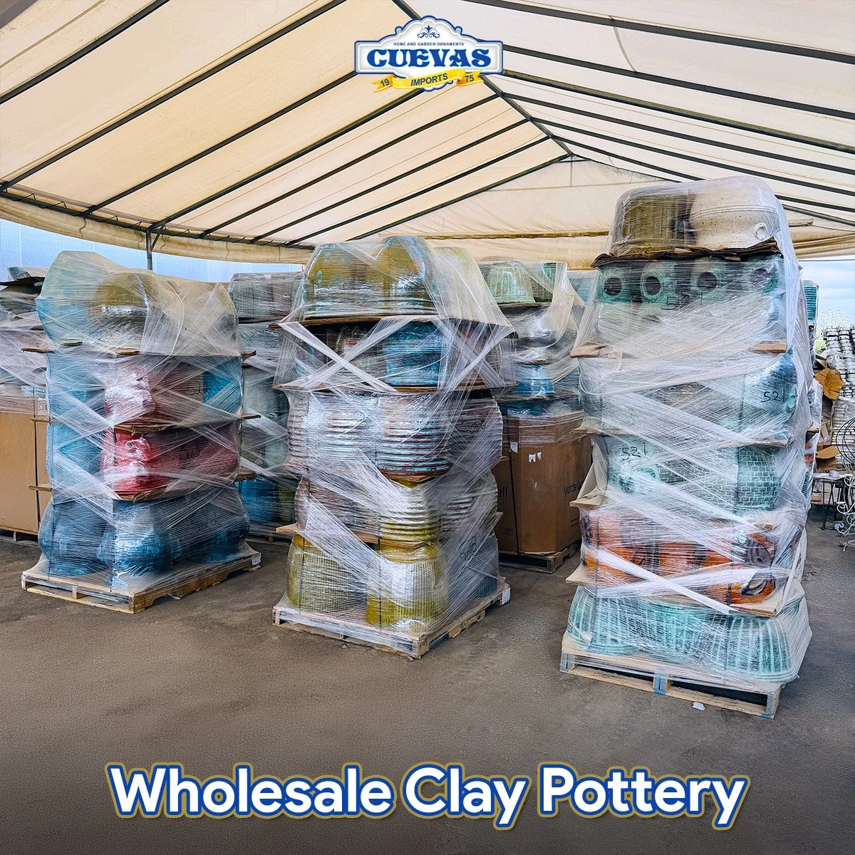 Stacks of ceramic clay pottery wrapped in plastic wrap on pallets at a wholesale clay pottery store under a canopy