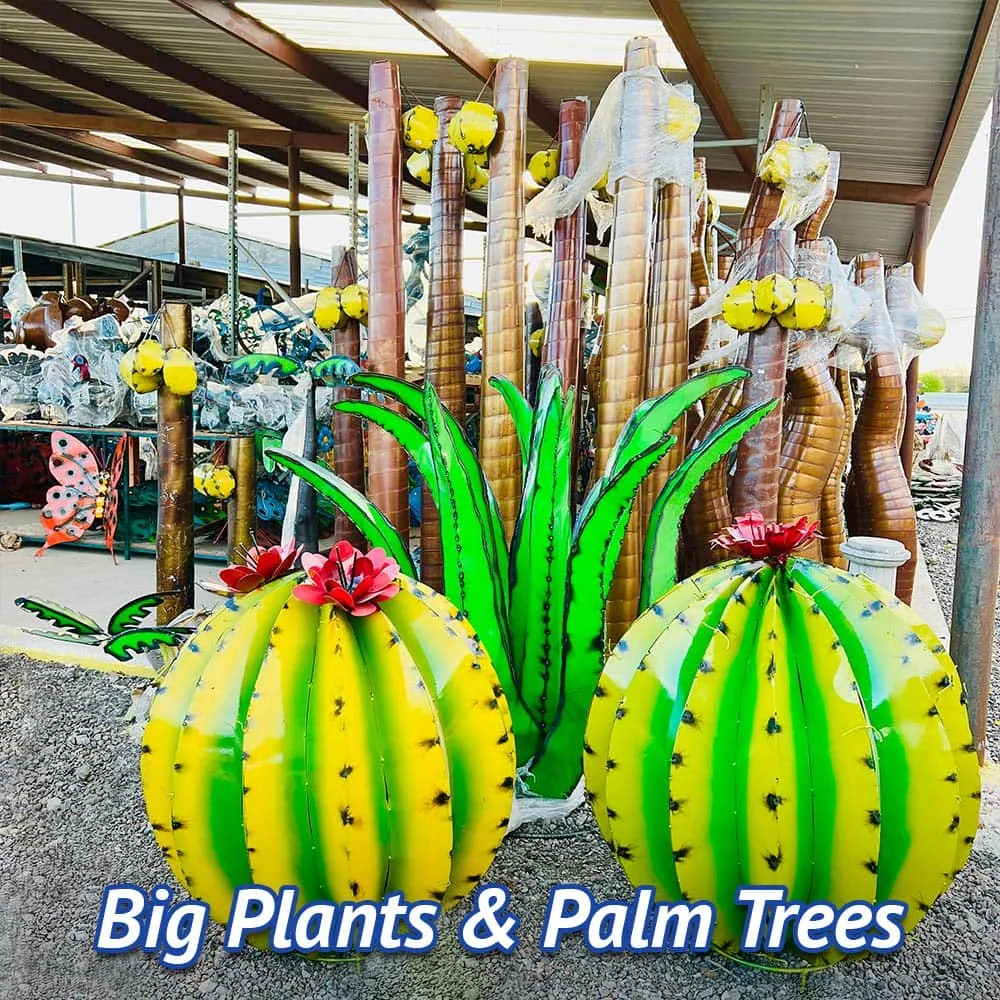 Colorful large outdoor decorations resembling cacti, palm trees, and big plants in a marketplace or garden store.
