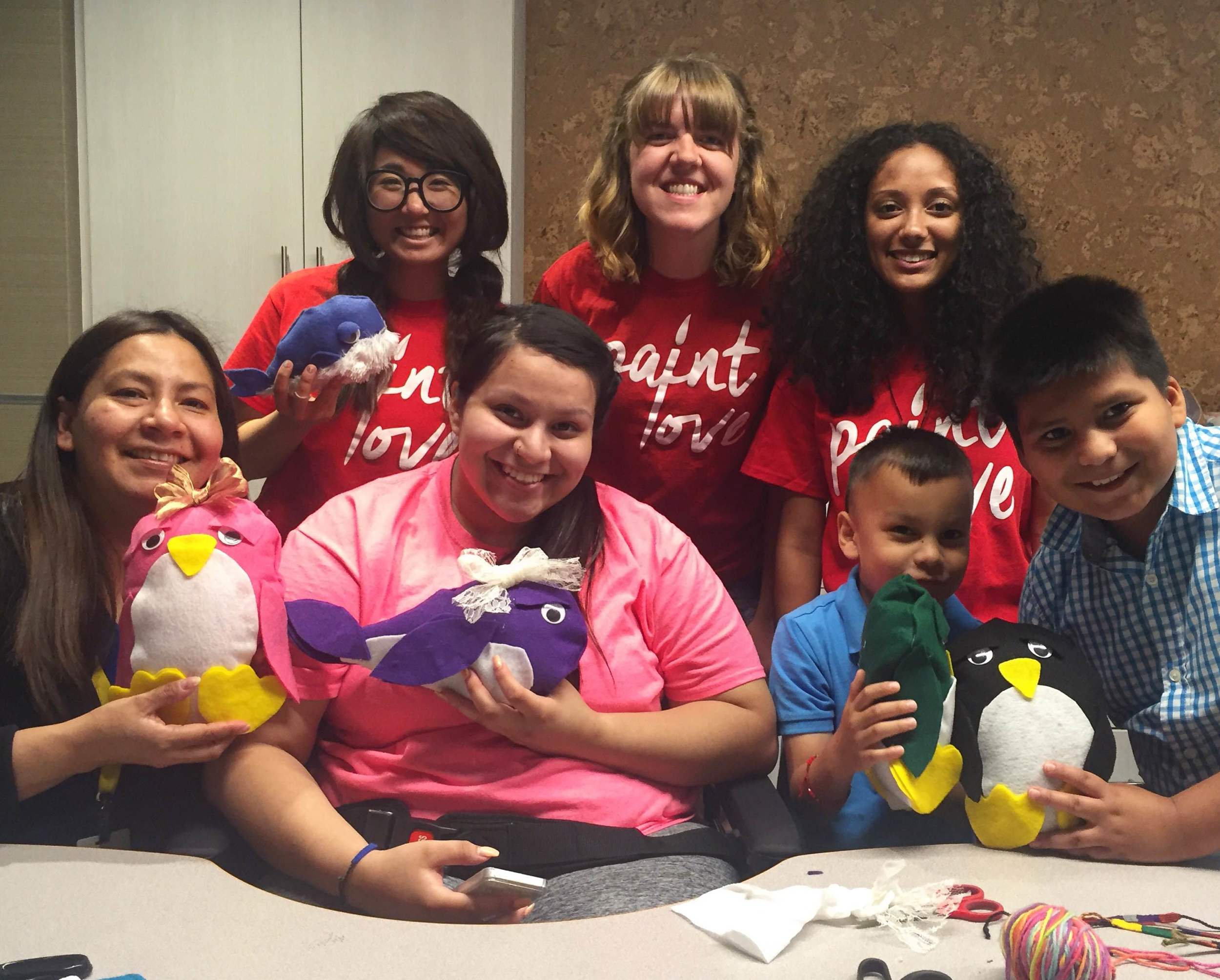 Artist Alice Lim, and Paint Love volunteers Mandy Goodwin and Laurel Wong pose with a family at the Ronald McDonald House. 