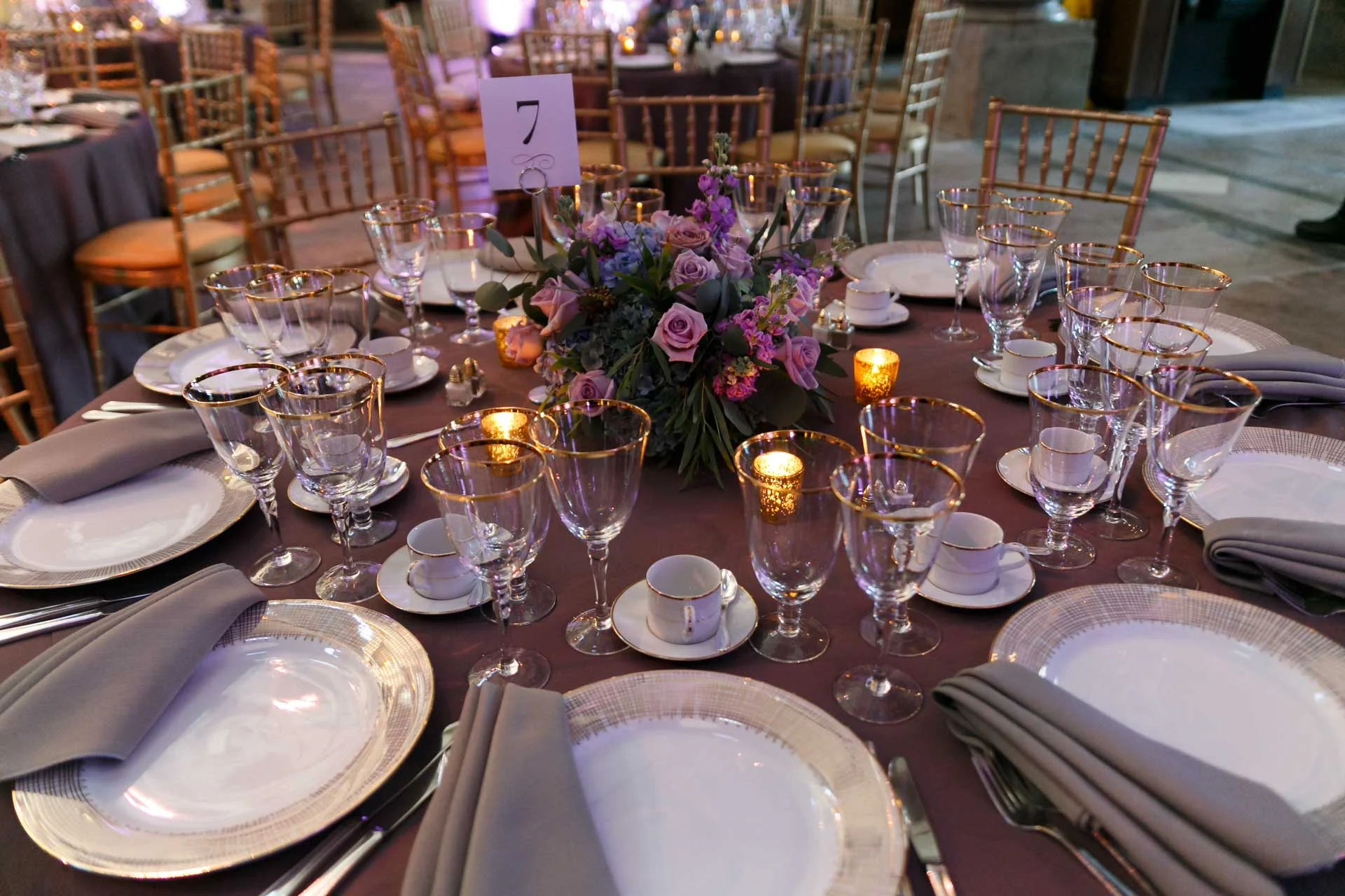 This set up was gorgeous with a perfect plum linen, gold accents and the flowers bringing in the dusty hues of blue, green and lavender. Catering and rentals by Occasions Caterers