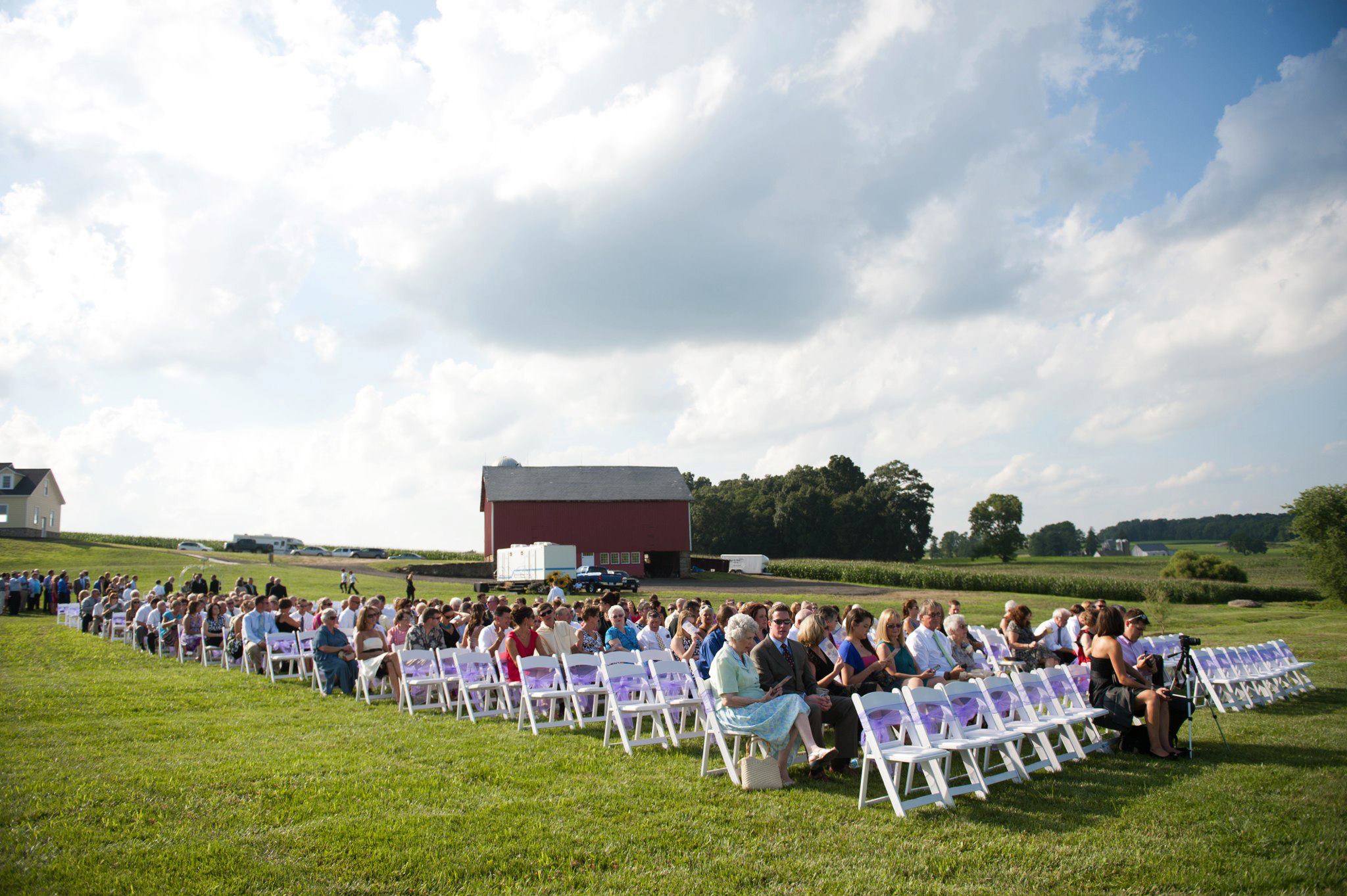Wedding ceremony with white padded garden chairs