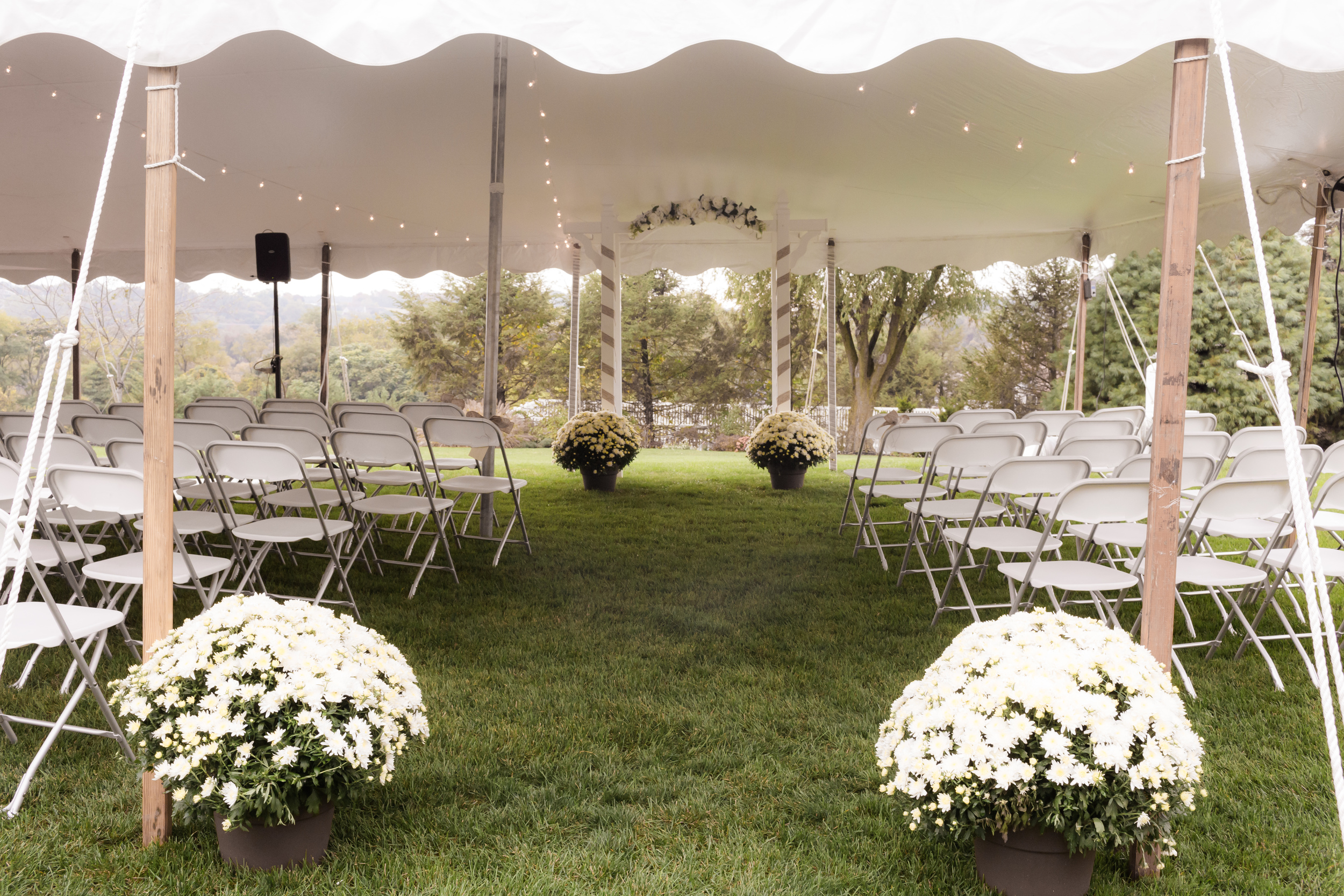 White wedding tent with white folding chairs