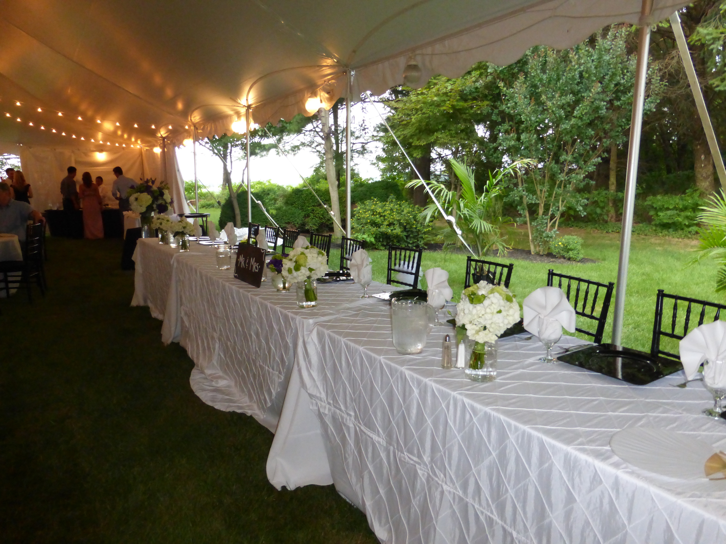 White wedding tent with cafe lights and globe lights