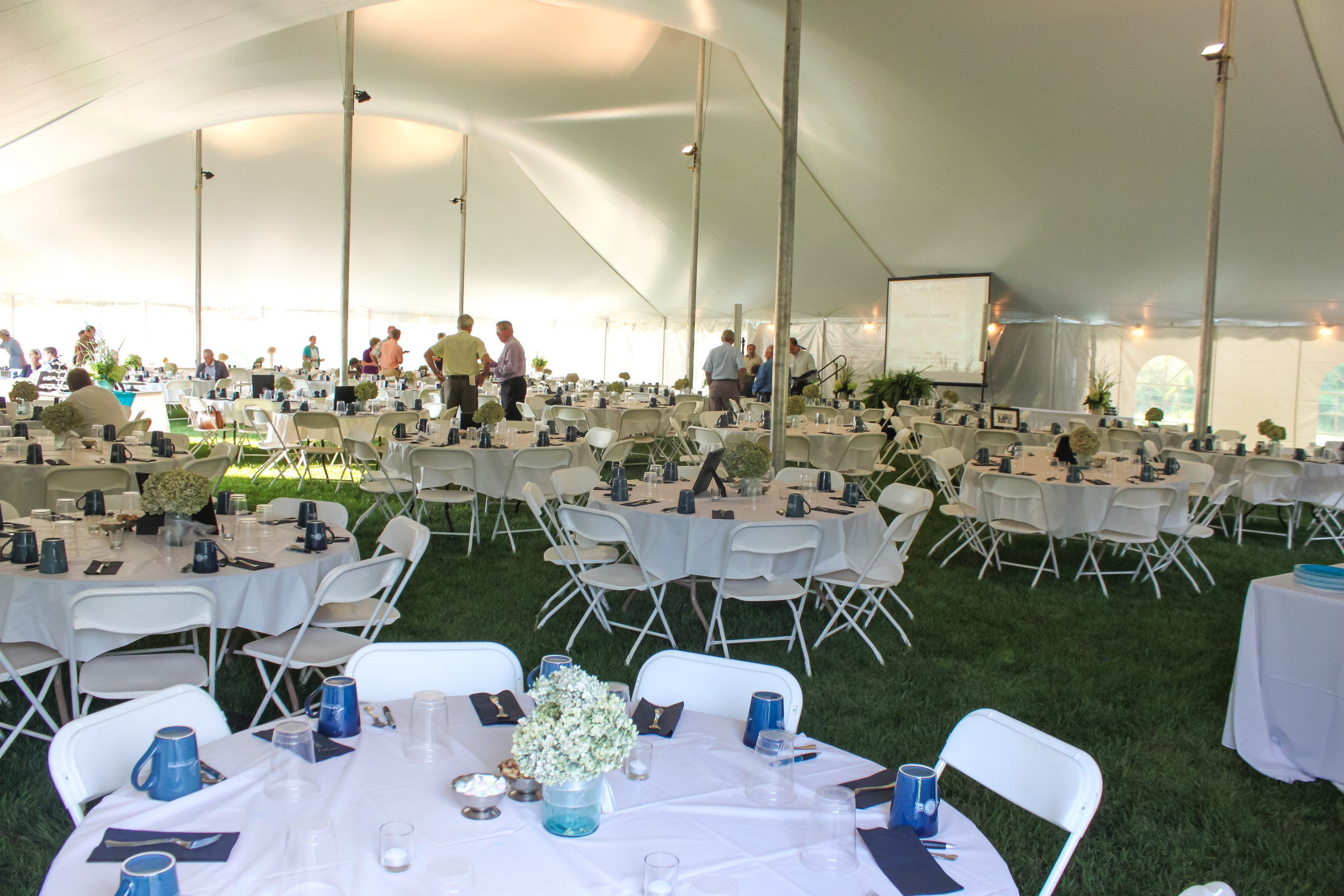 White folding chairs and 60" round tables