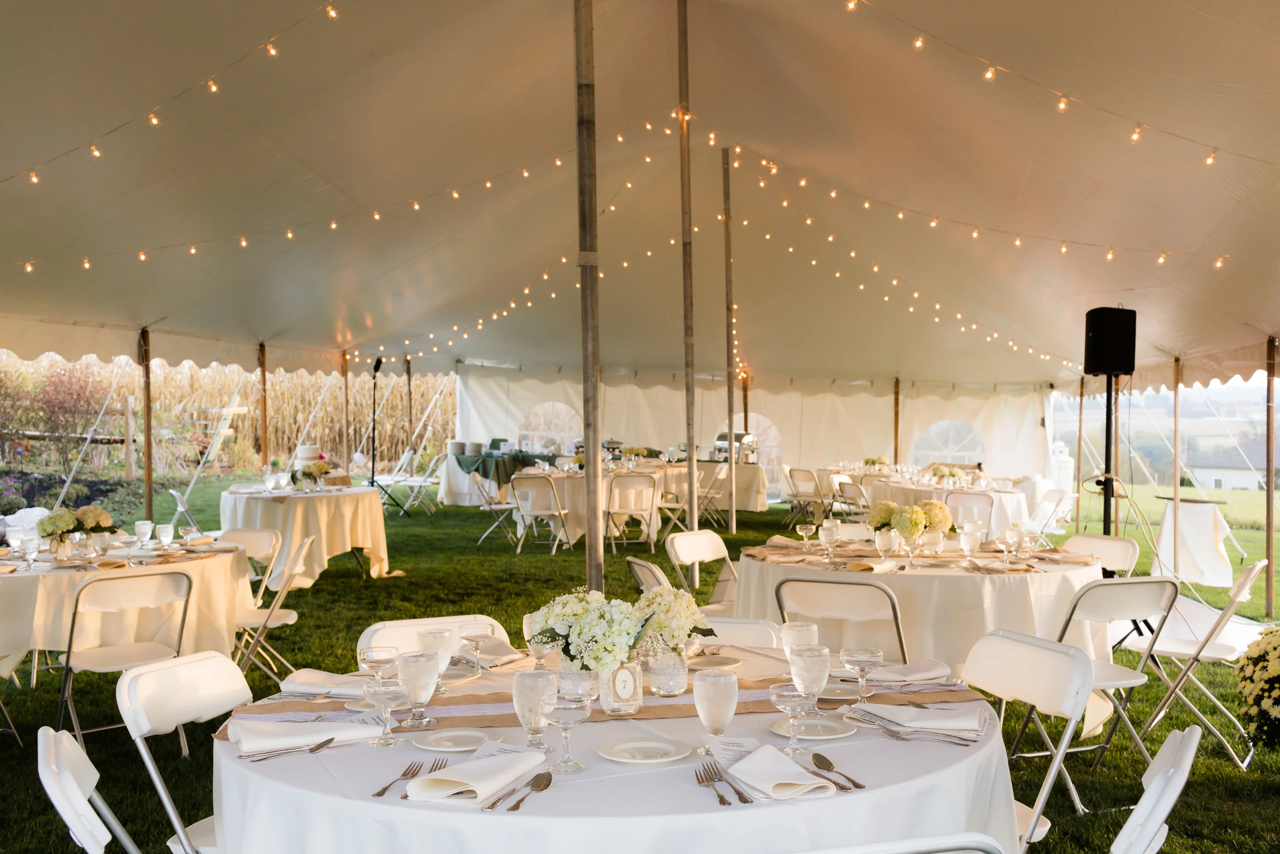 White folding chairs and round tables