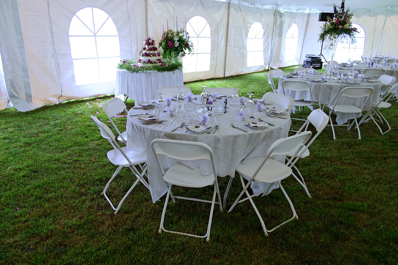White folding chairs and 60" round table