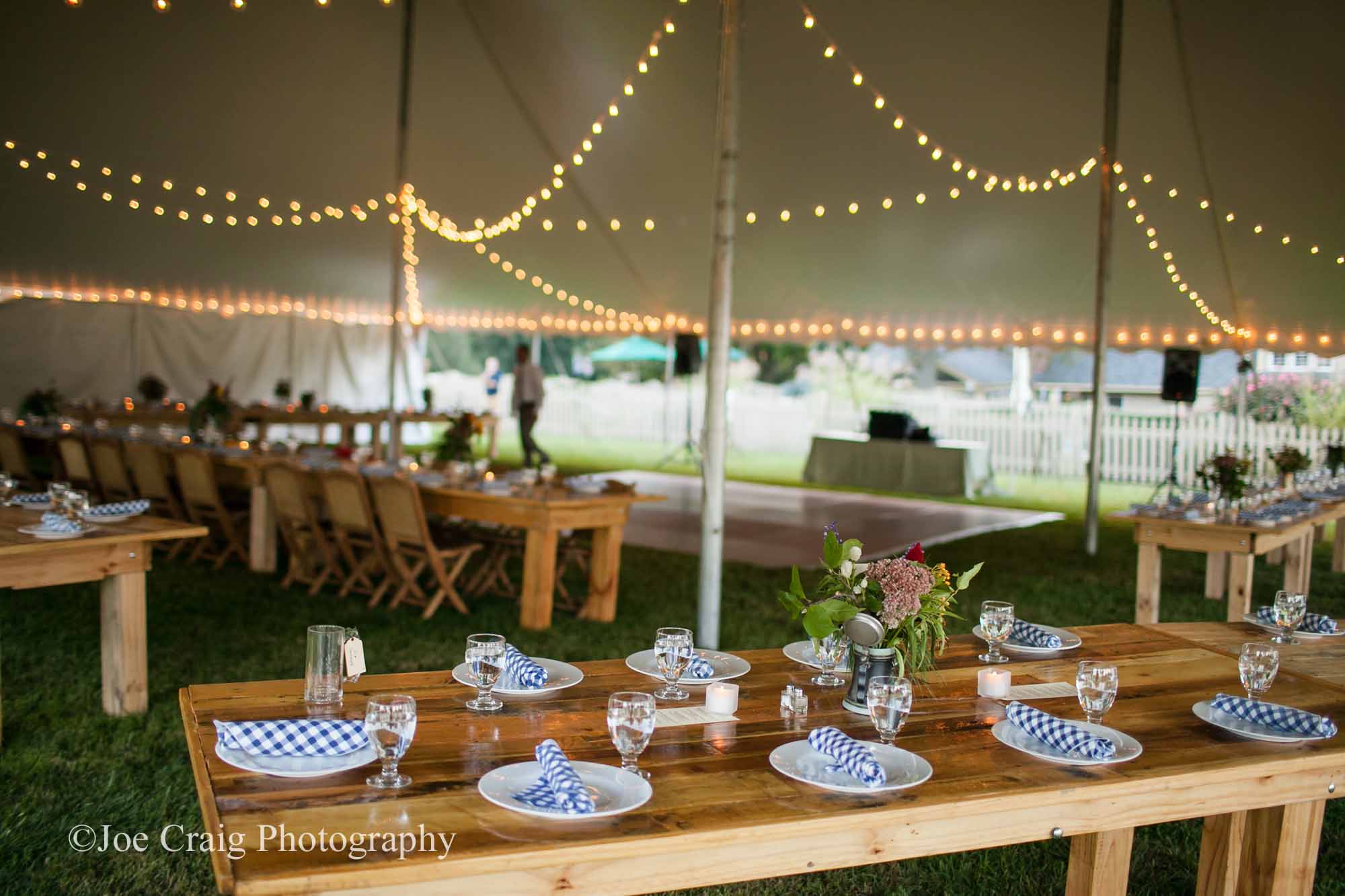Wedding tent with farm tables and cafe lights