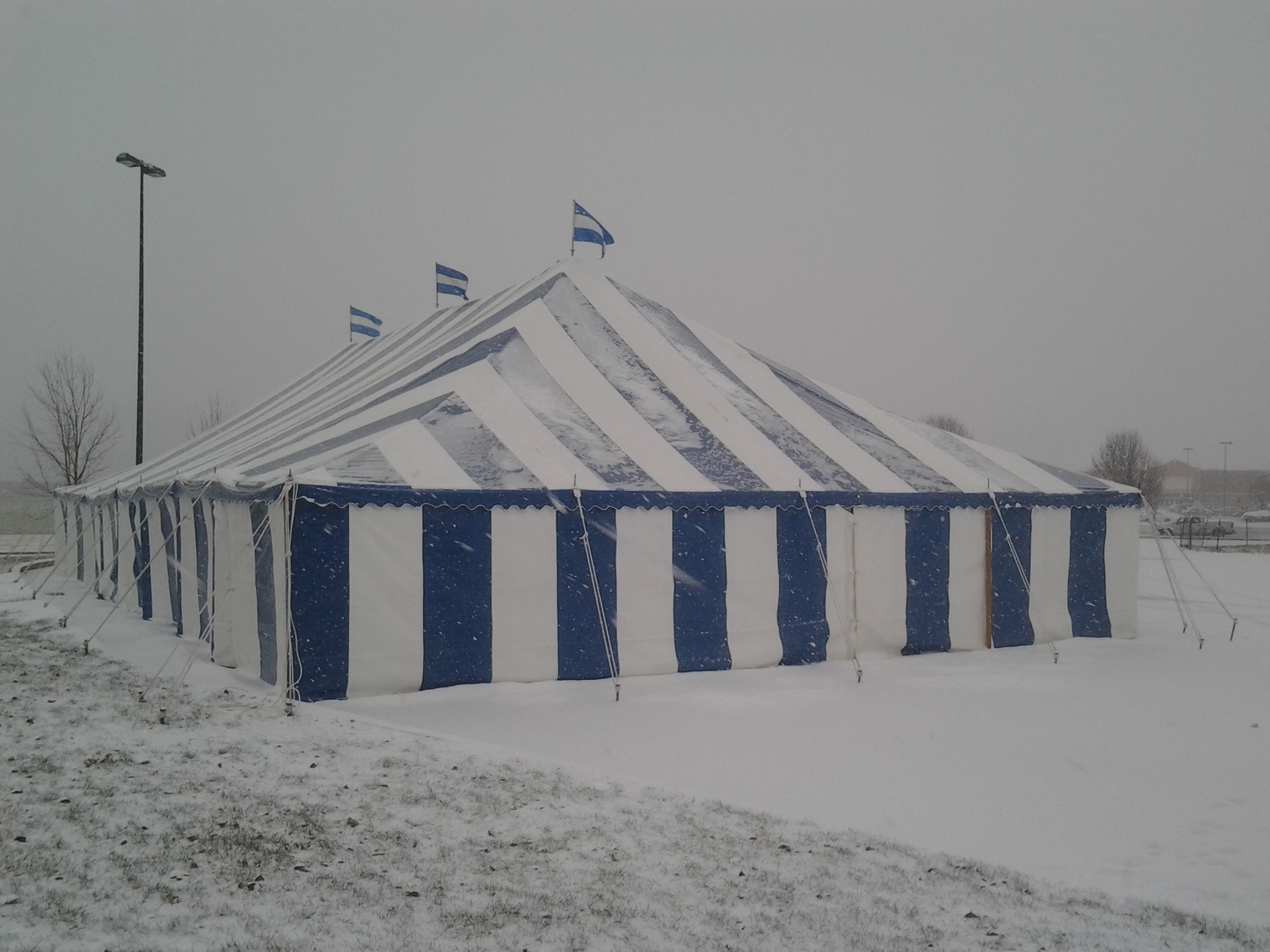 Blue and white striped tent in a snow storm