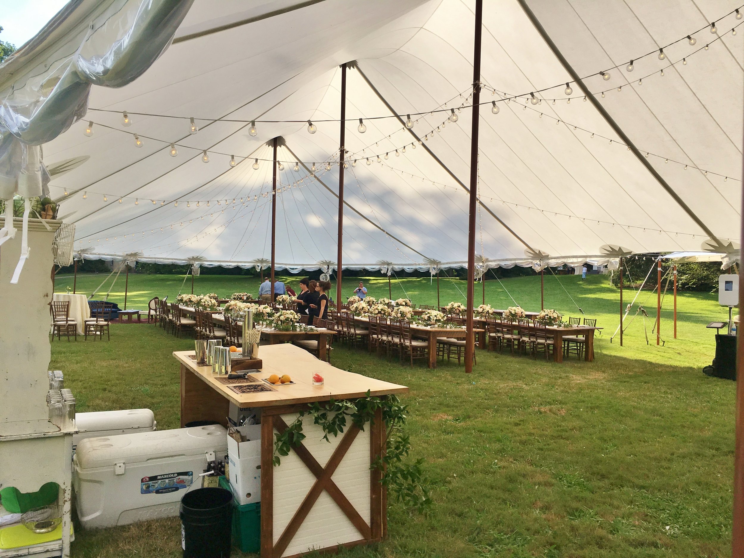 Sailcloth wedding tent with cafe lights and faux wooden poles