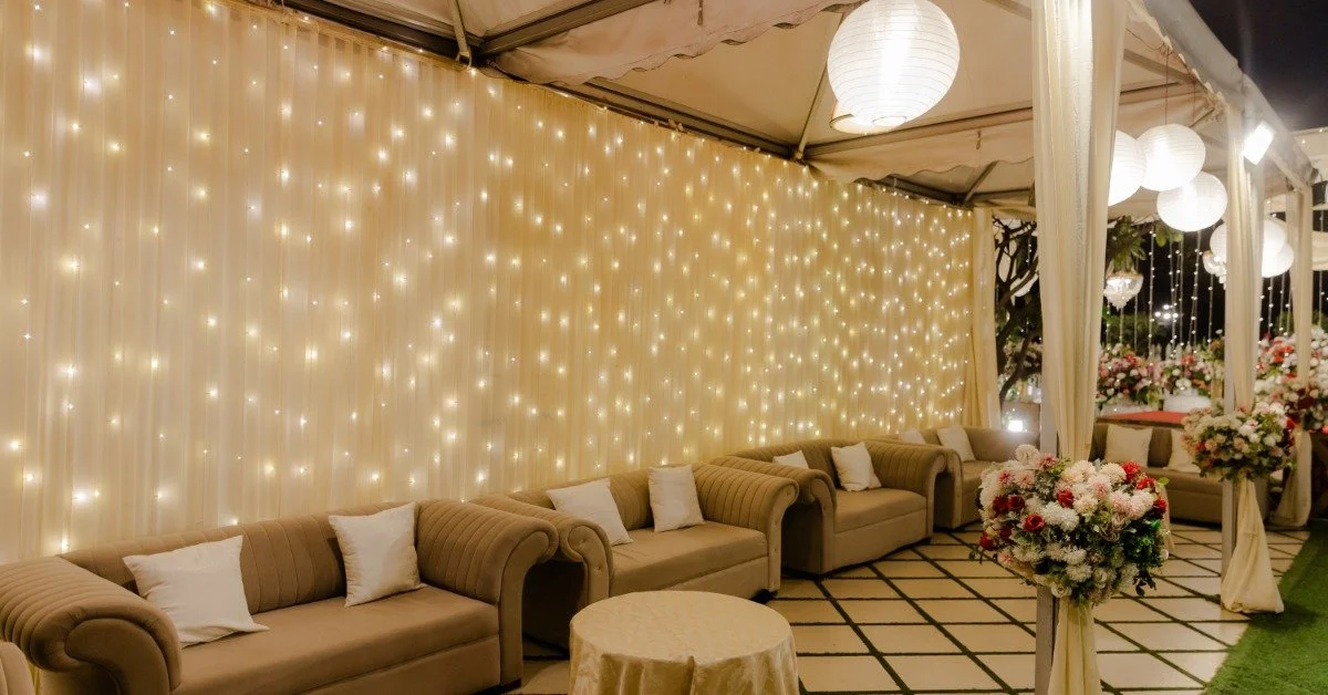 Five couches and a table neatly placed in a brightly lit lounge area at an elegant outdoor event space.