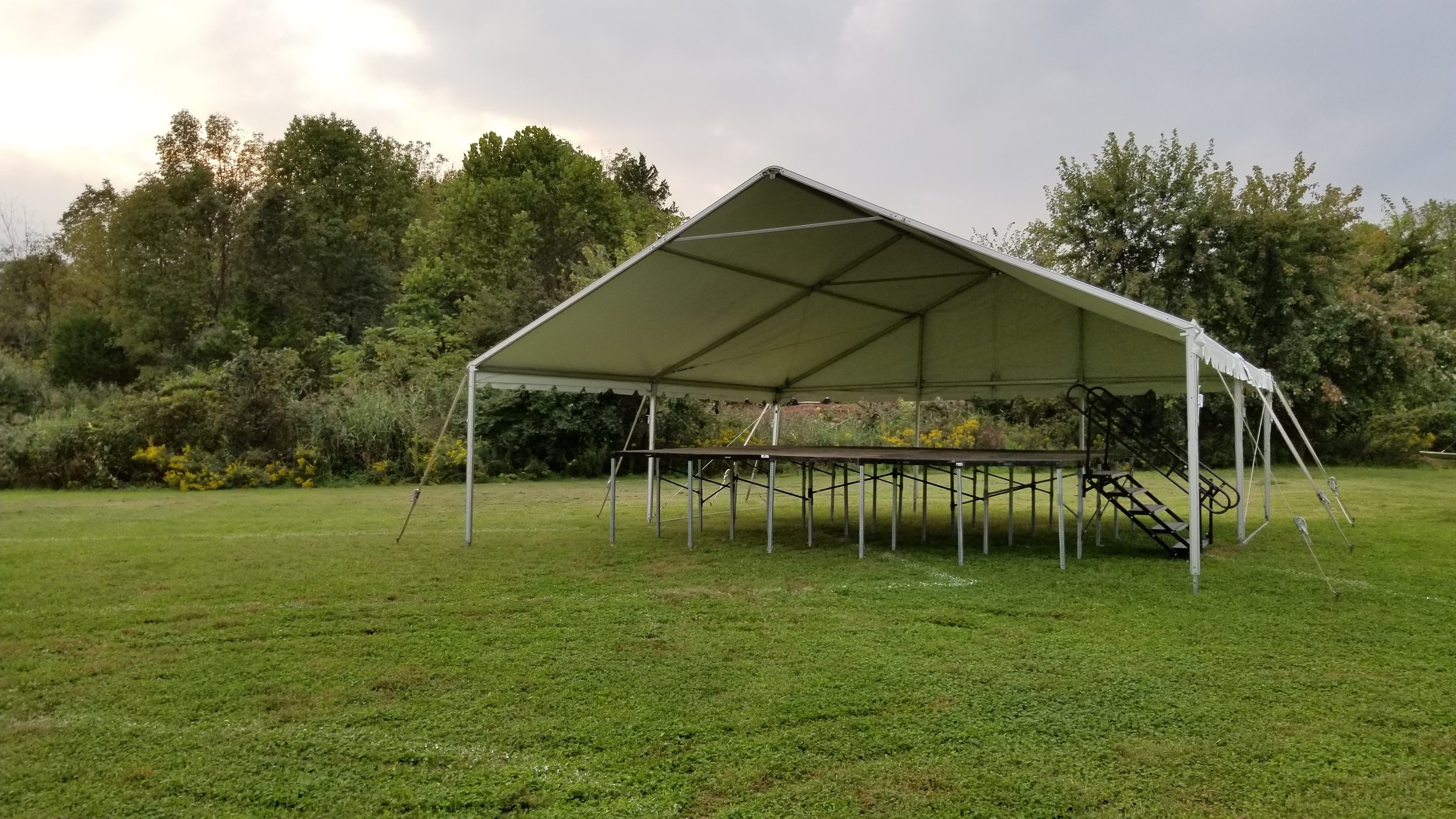 30' x 30' white frame tent with open gable and stage inside