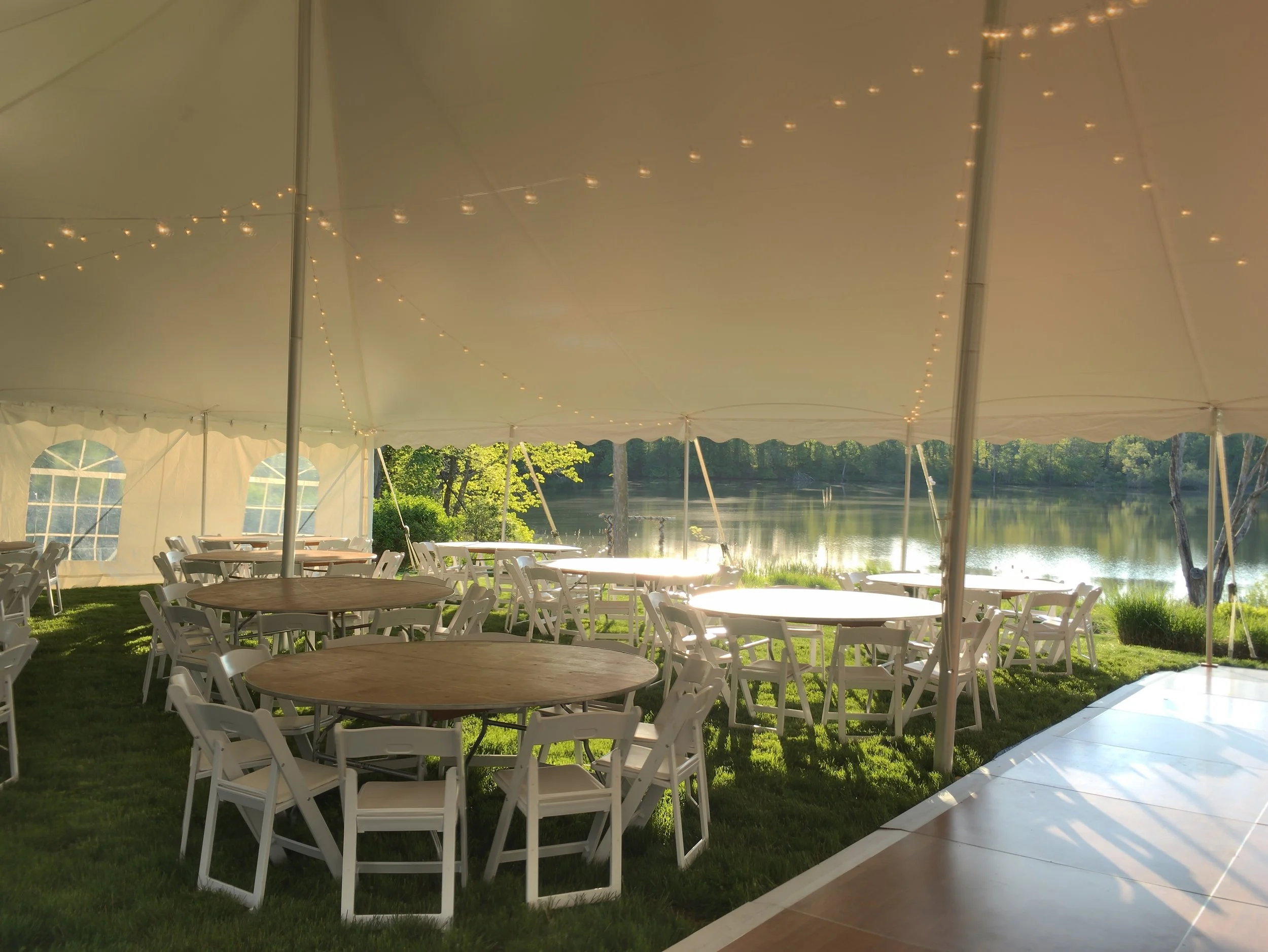 cafe lighting, dance floors, white padded chairs and round tables for your tent wedding