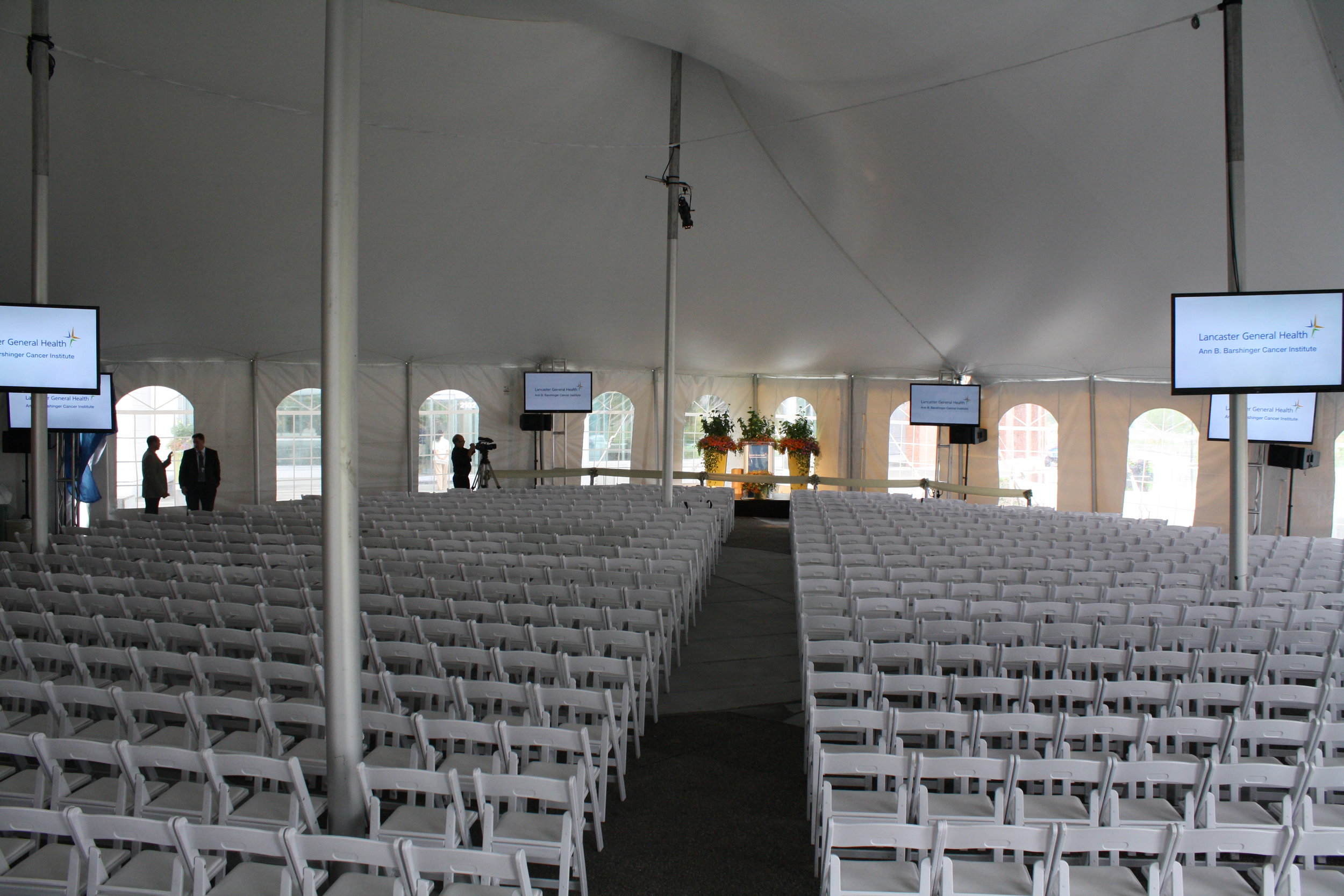 Large amounts of white padded folding garden chairs for your tent event