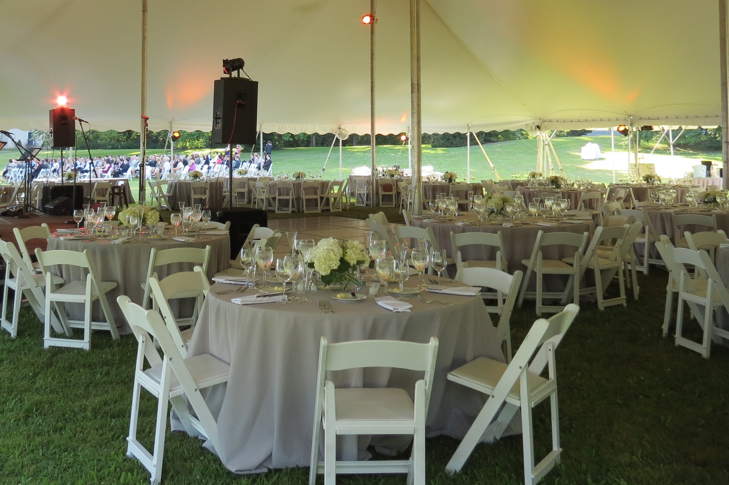 Round tables and white padded folding garden chairs for your tent reception