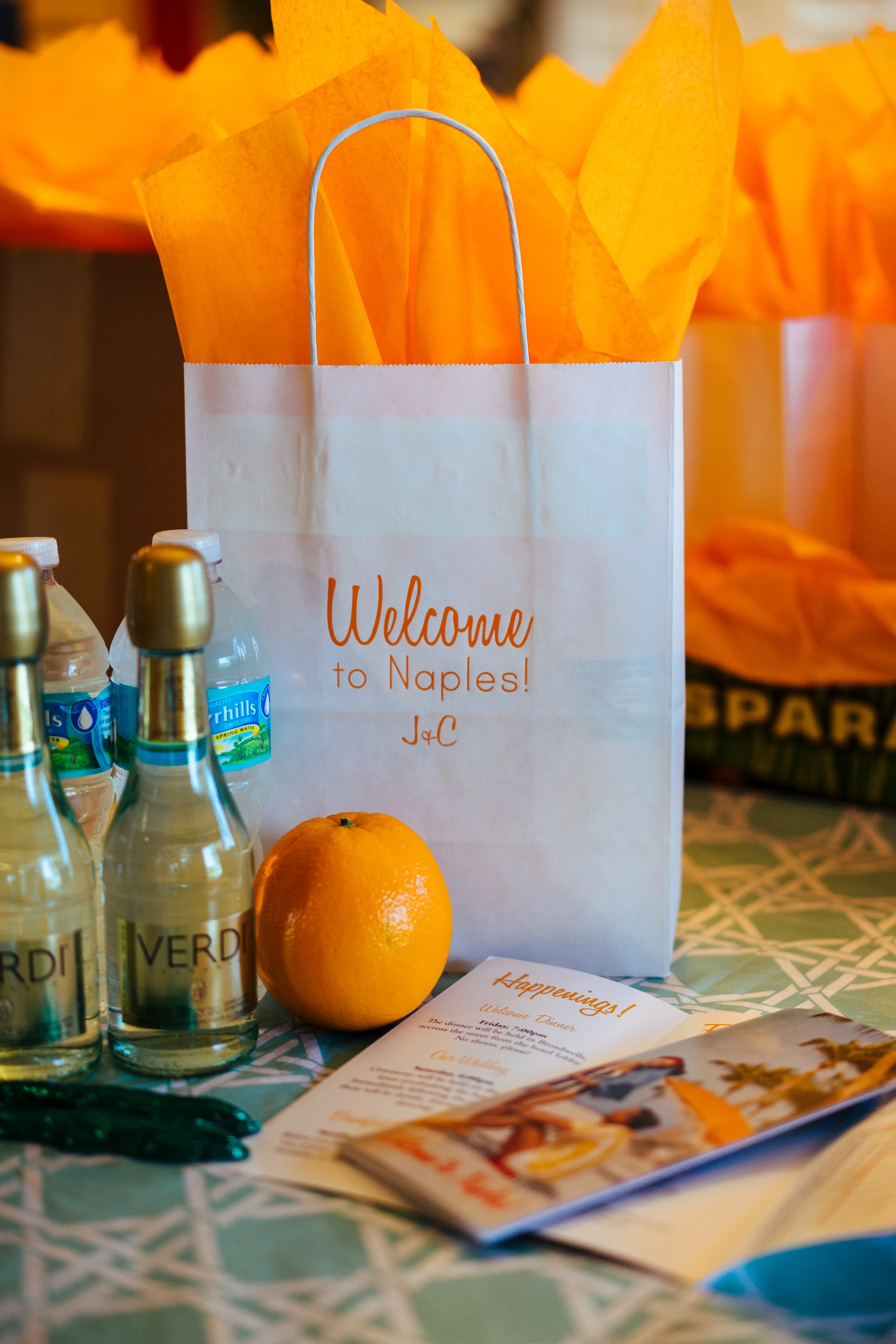 A glimpse at our welcome bags. We wanted these to be very Floridian (and scream vacation), so we included oranges, little chocolate alligators, and an itinerary for the wedding which we designed to look like a retro tourism pamphlet. ...oh and champagne, just 'cuz.