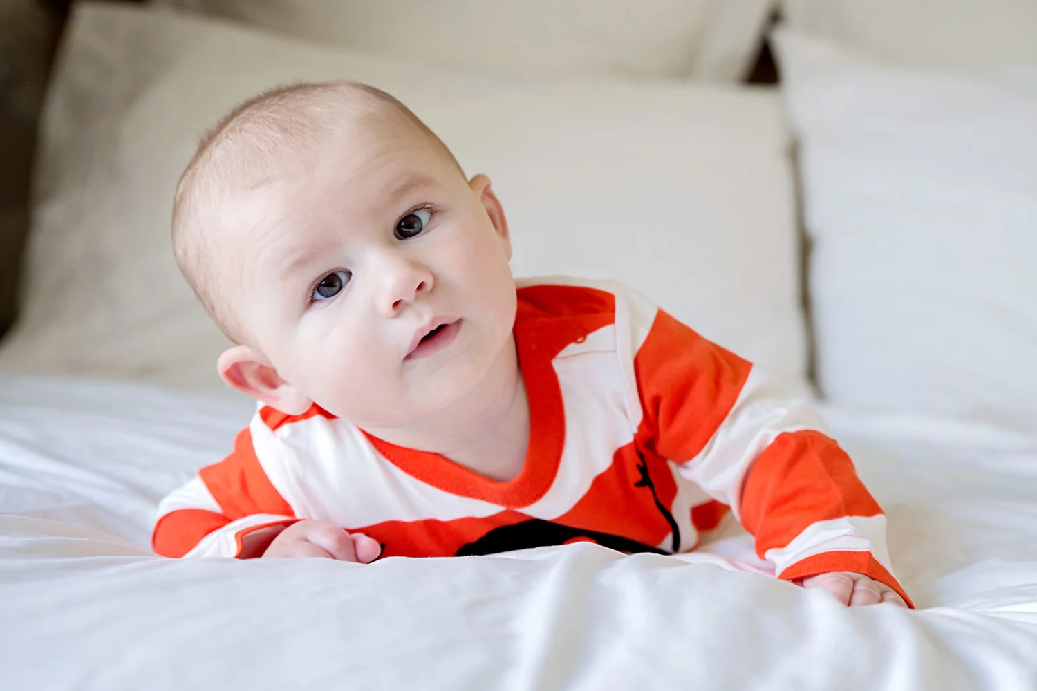Baby pictures - 8 month old Harry on his tummy on a big bed