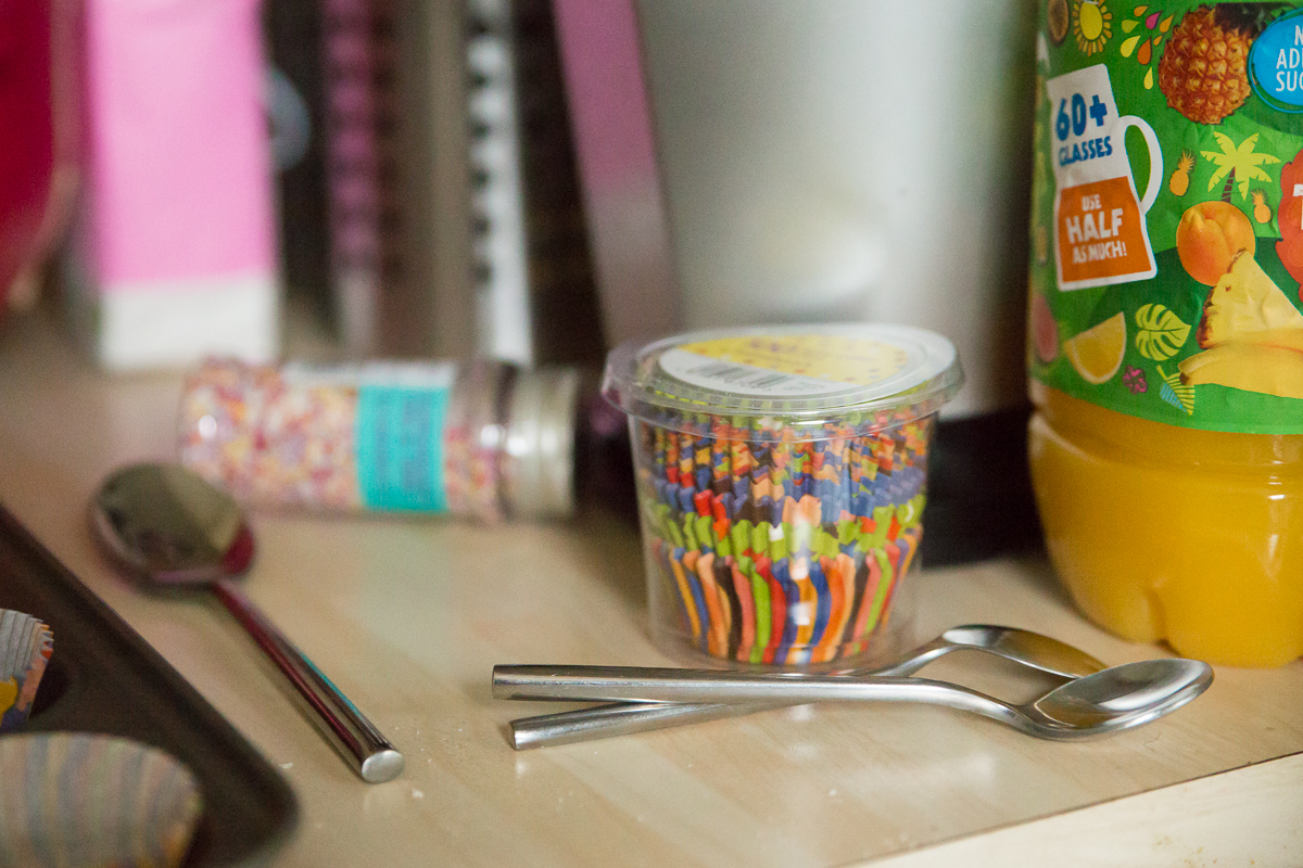 Colourful cake sprinkles, cup cake cases and spoons. 