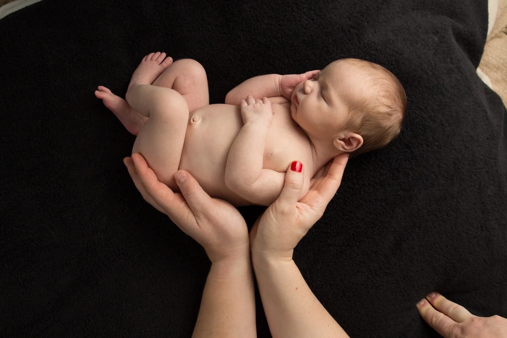 baby boy laying in his parents hands at his photo shoot in hemel hempstead