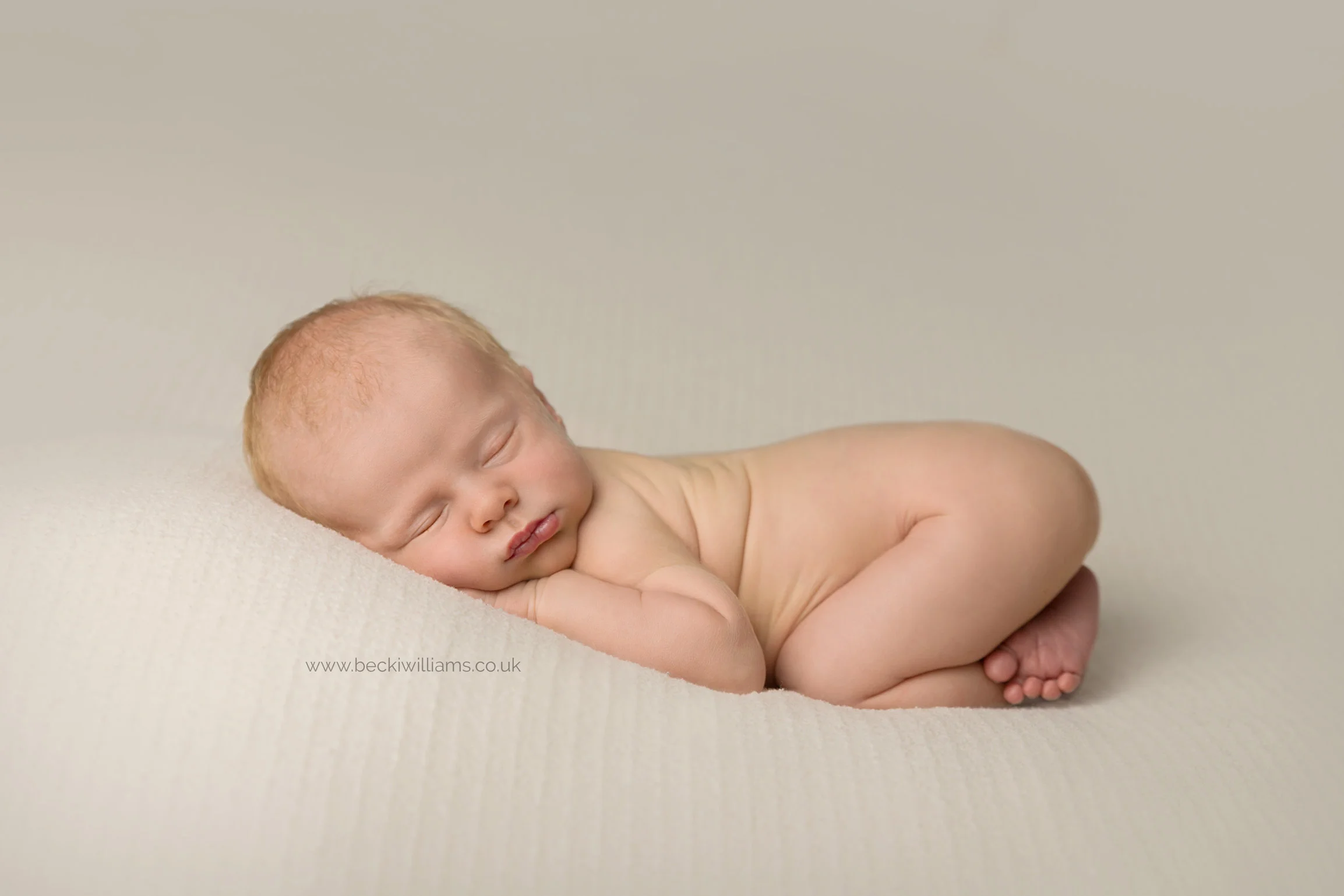 newborn baby boy laying on his tummy at his photo shoot in hemel hempstead