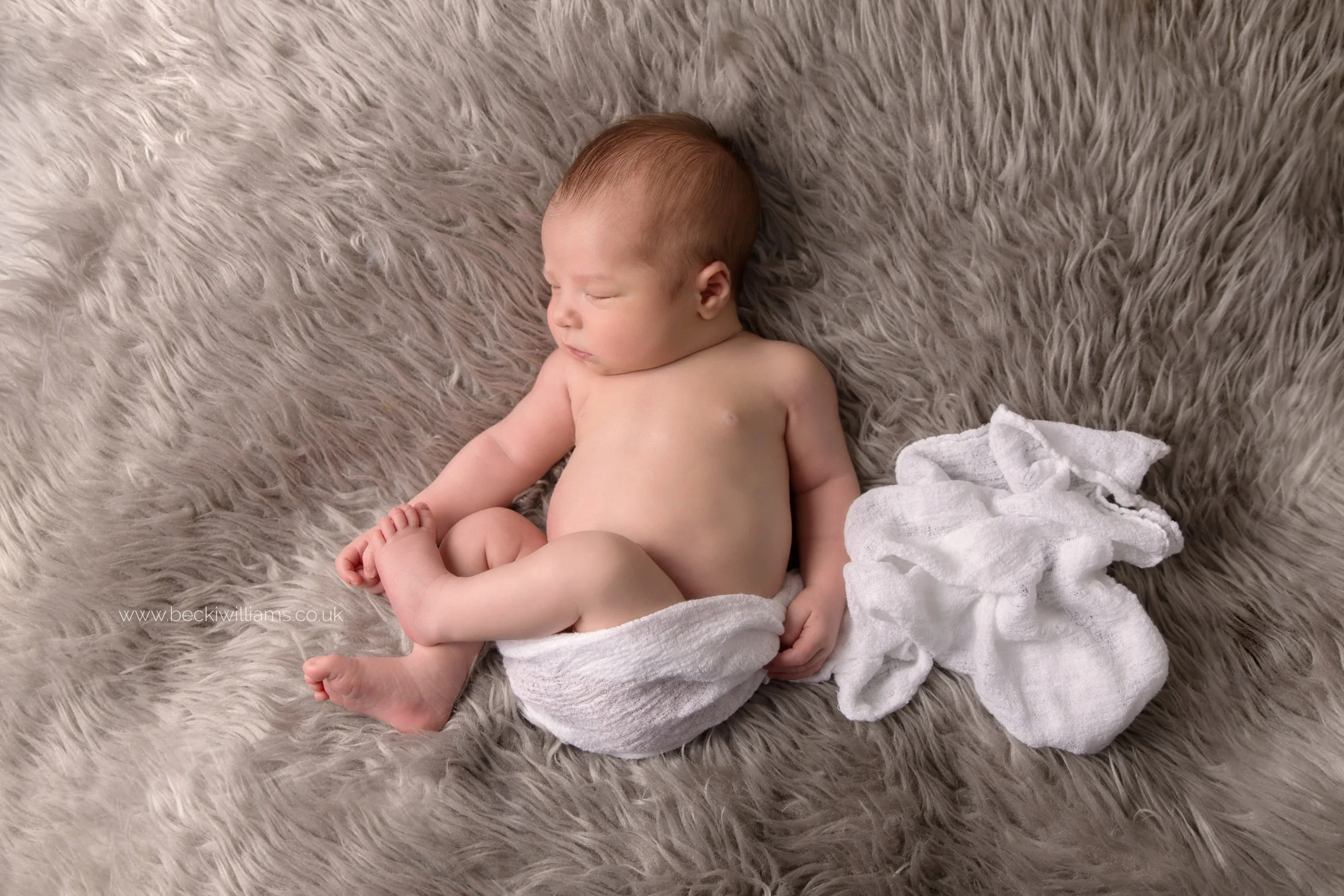newborn-photography-hemel-hempstead-hertfordshire-studio-posed-grey-fluffy-white-wrap-asleep.jpg
