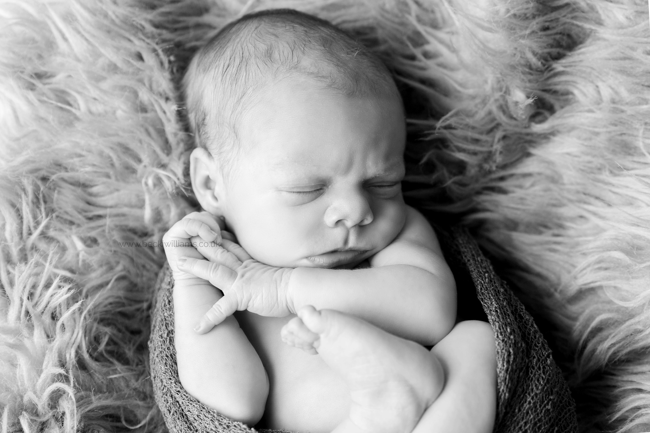 newborn-photography-hemel-hempstead-black-and-white-faux-furr-curled-up.jpg