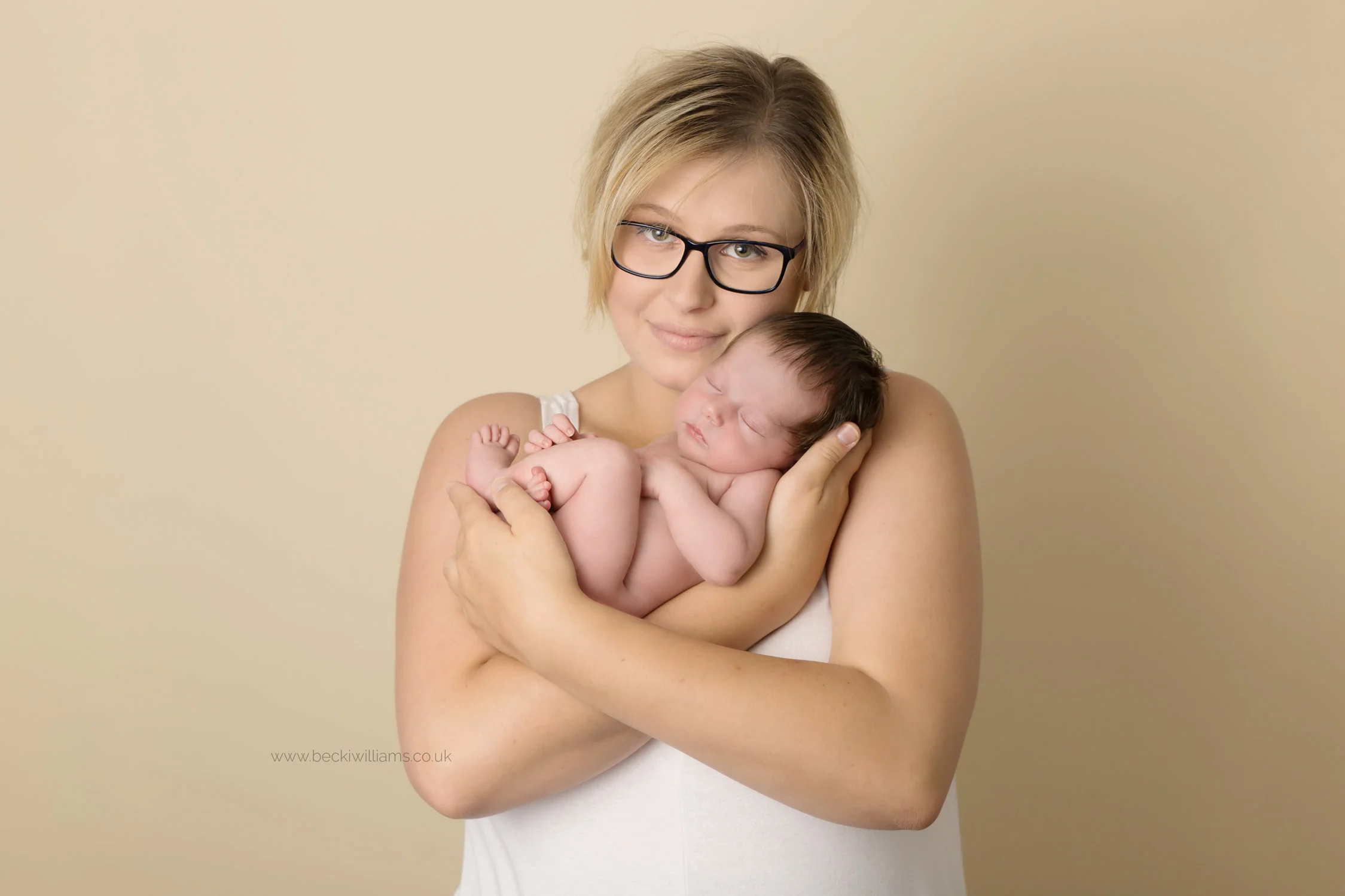 new mum holding her baby girl at their newborn photo shoot in hemel hempstead