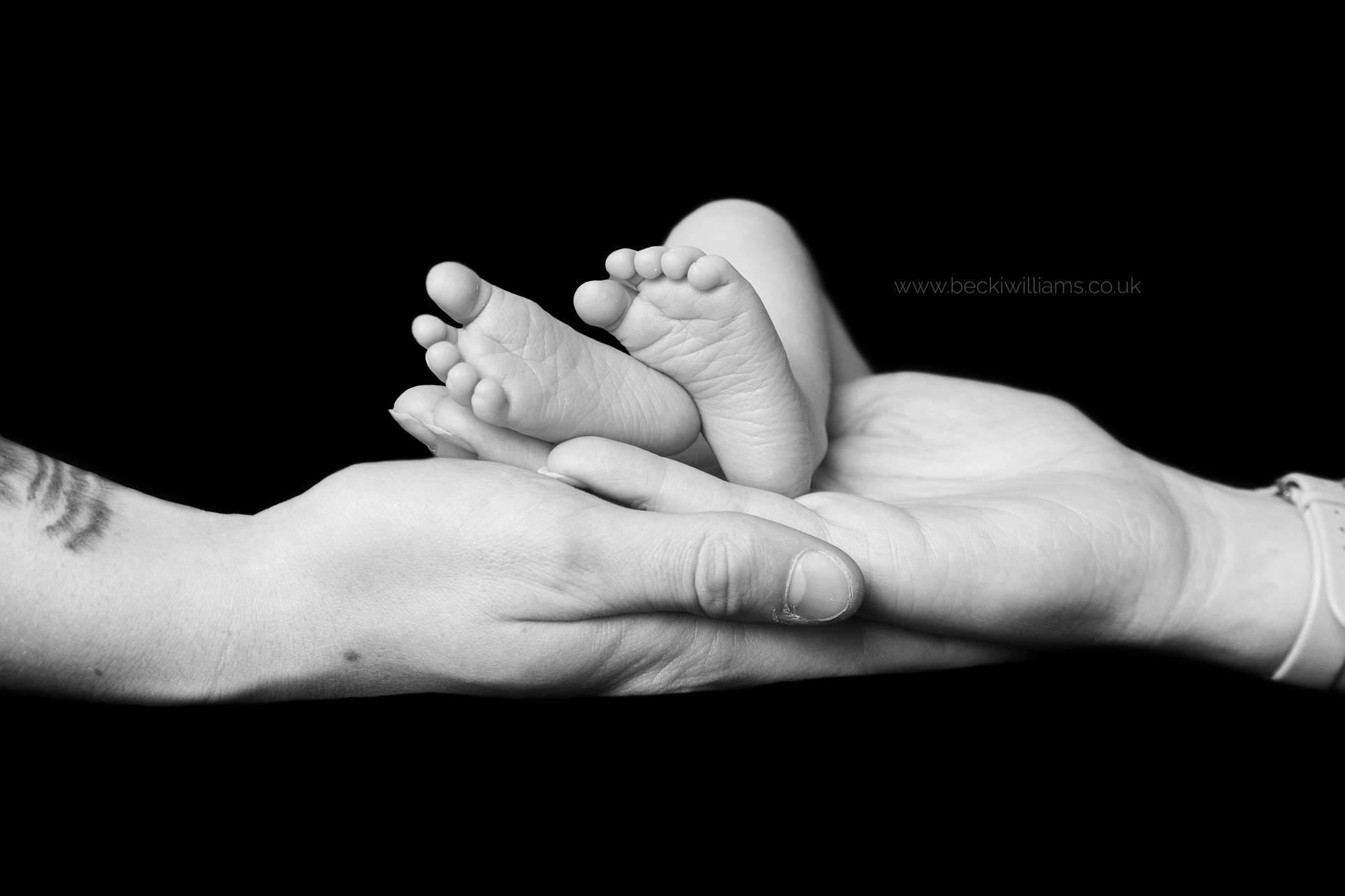 newborn-photography-hemel-hempstead-baby-feet-on-parents-hands.jpg