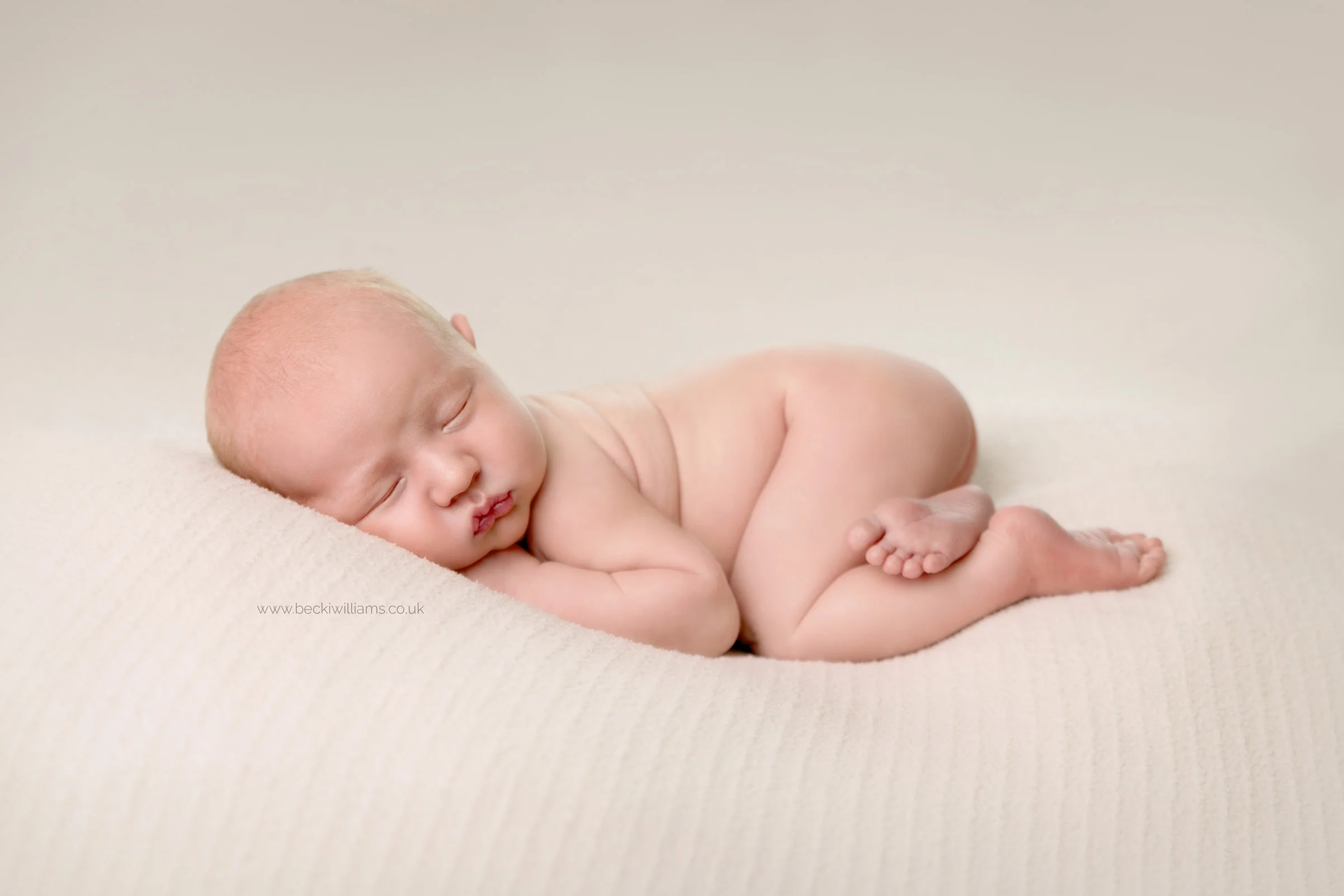 cute newborn baby boy laying asleep on his tummy for his newborn photo shoot in berkhamsted