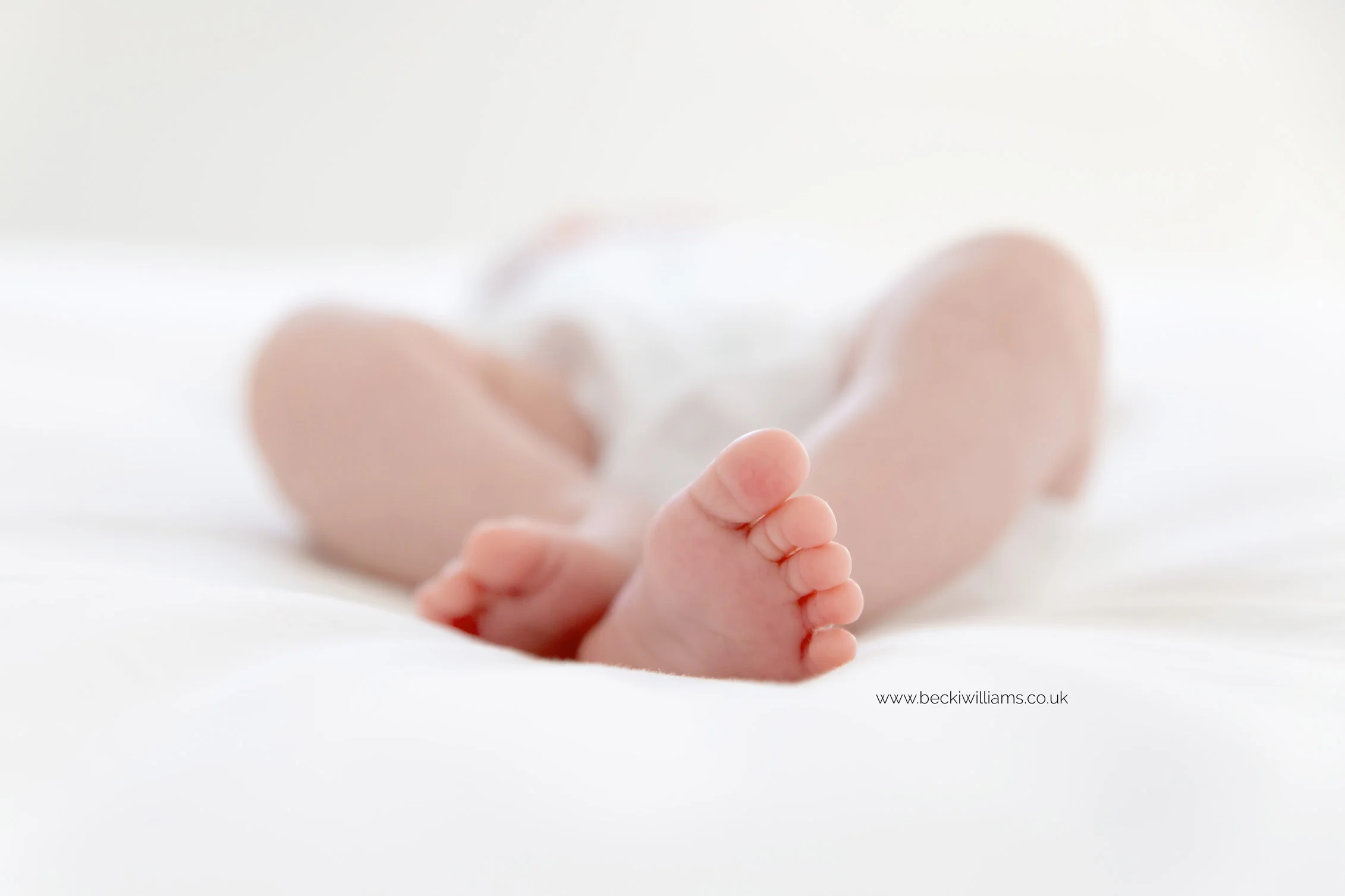 natural unposed photo of a newborns baby feet on a white bed in st albans