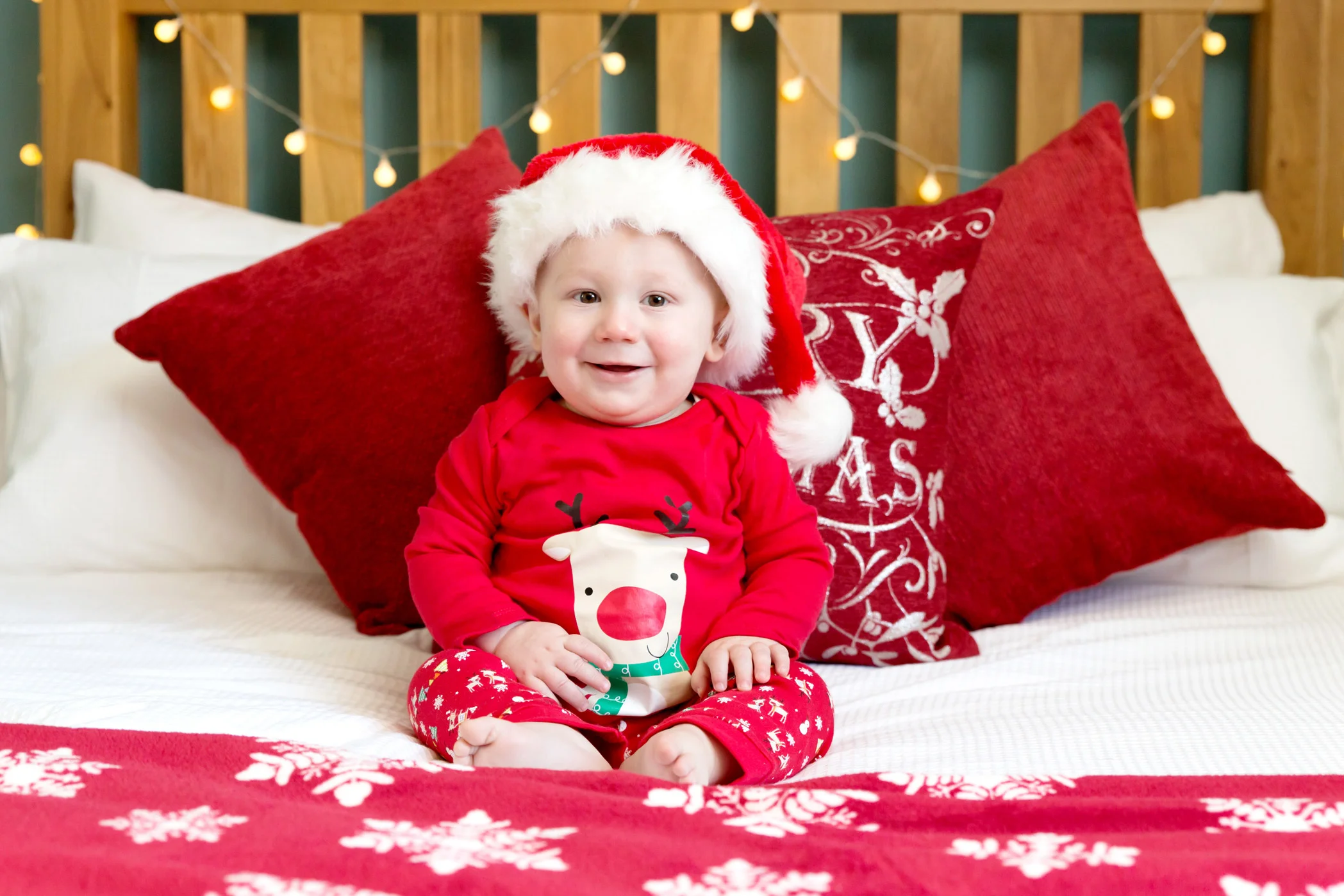 baby boy sitting on a christmassy decorated bed for a christmas photo shoot in hemel hempstead, herfordshire