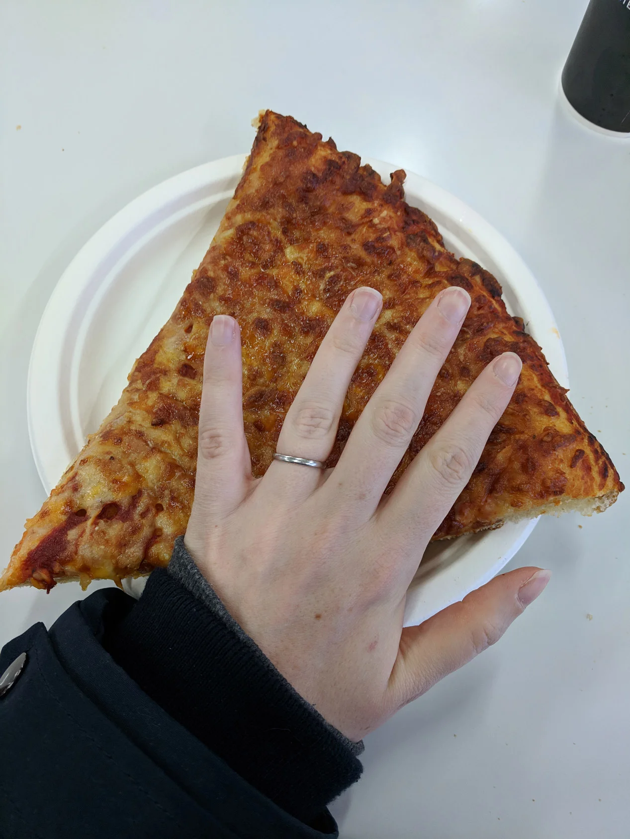 giant slice of pizza from costco in watford with hand hovering over it for scale