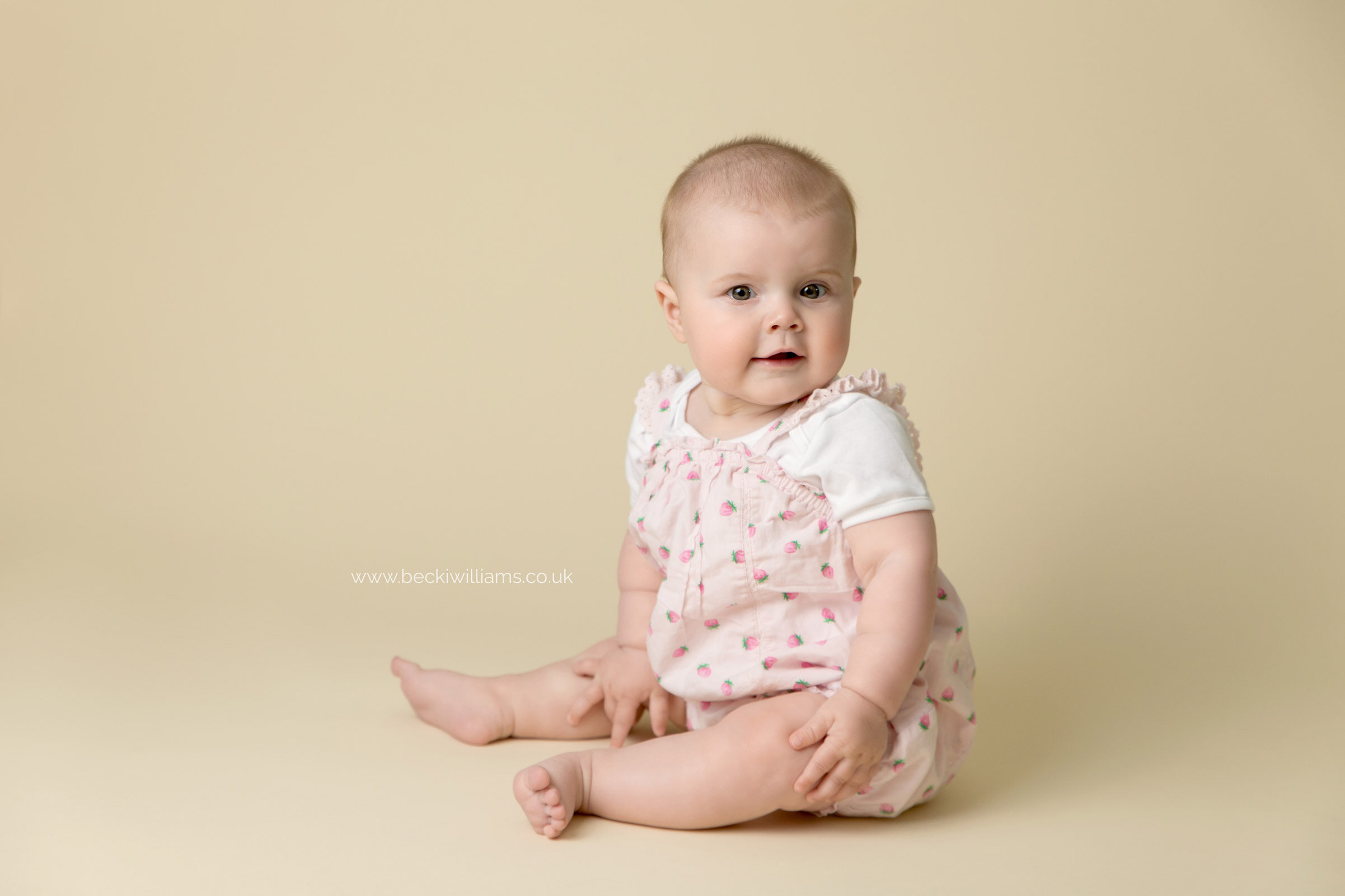 Vertical portrait of baby girl 6 month old in cotton dress on bed Stock  Photo by evgeniya_grande
