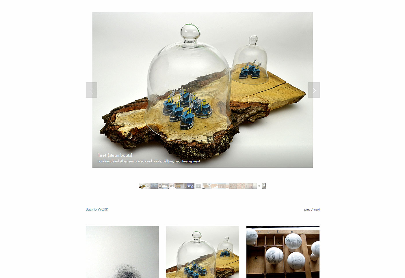 sculpture of paper boats within a bell jar