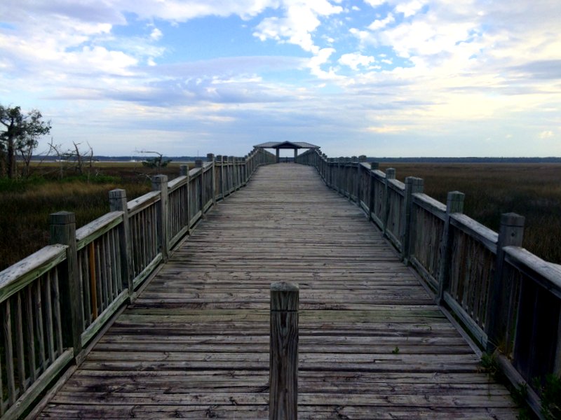 A wooden walkway stretching out over a marsh in St. Marys, Georgia. 