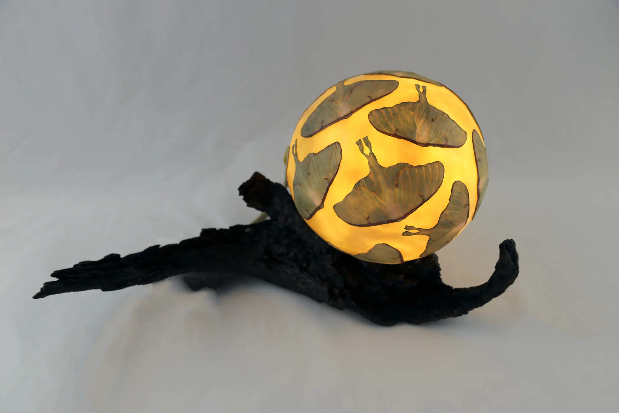 "The Sacred in the Night" (25 x 14 x 12) (Macro photo of a luna moth discovered on the ground in the pre-dawn light, swarming on a globe made from beeswax-layered mulberry paper, lighted by LED light internally, and mounted on wood from our land... This is a pedestal piece).