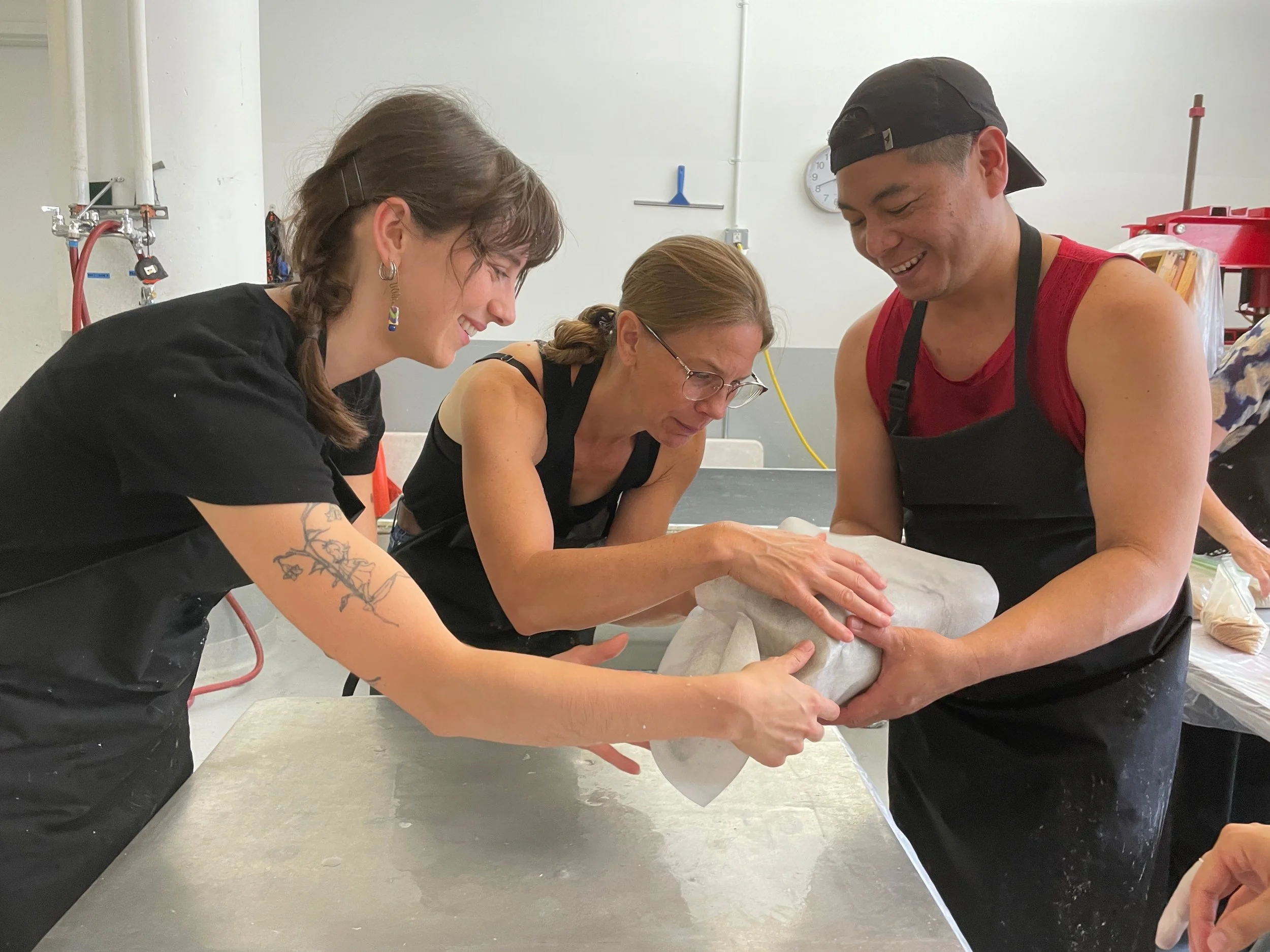  Student practices laminate casting in Paper Institute workshop taught by Lee Running (center) with assistance from studio intern Daphne Wilson (left) 