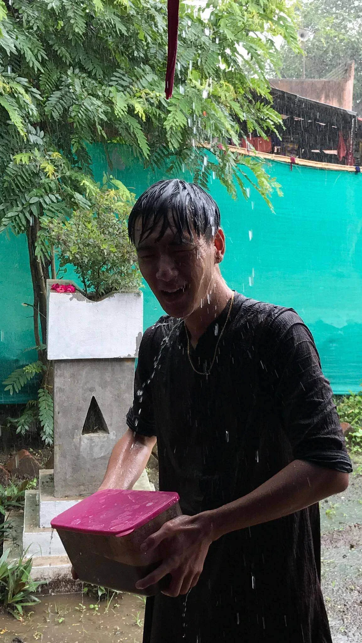 Michael caught in a monsoonal downpour, after assisting Sudam in the fields all day. 