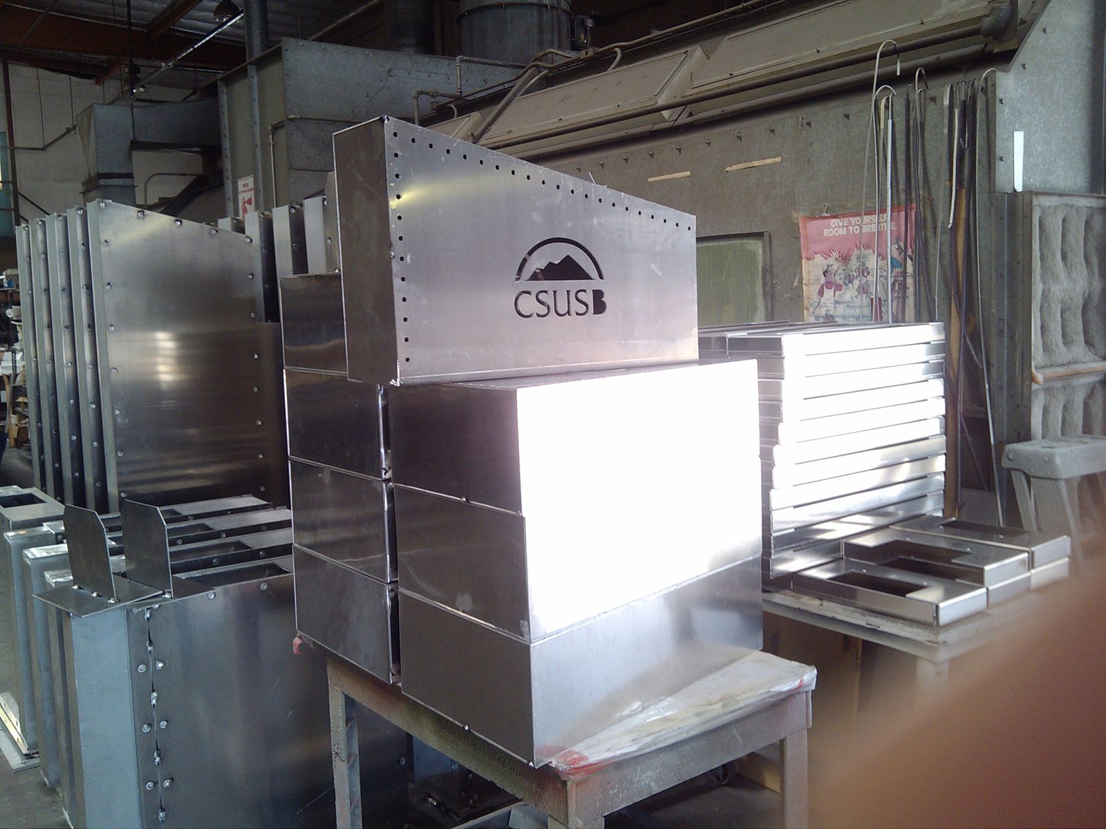 Fabricated aluminum sign components prior to paint and assembly. Fully welded aluminum cabinets, laser-cut logo for internally illuminated push-thru graphics.