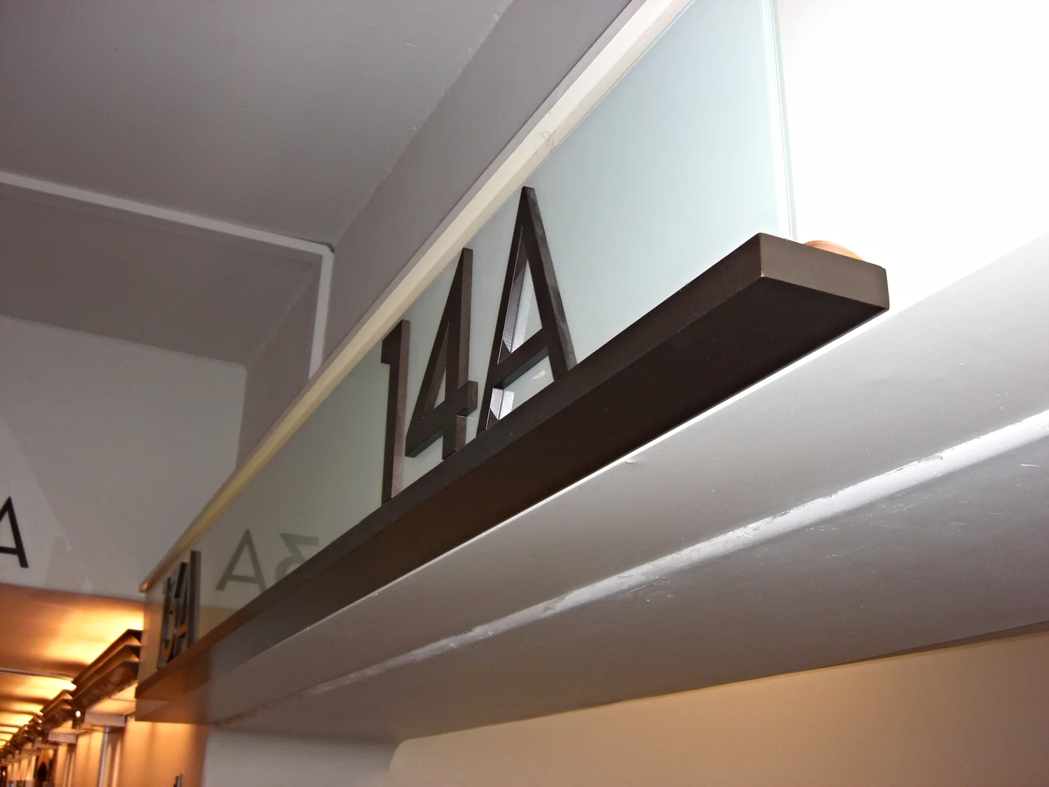  ...tempered glass backer panel with frosted finish, fabricated aluminum painted letters mounted flush to glass. 